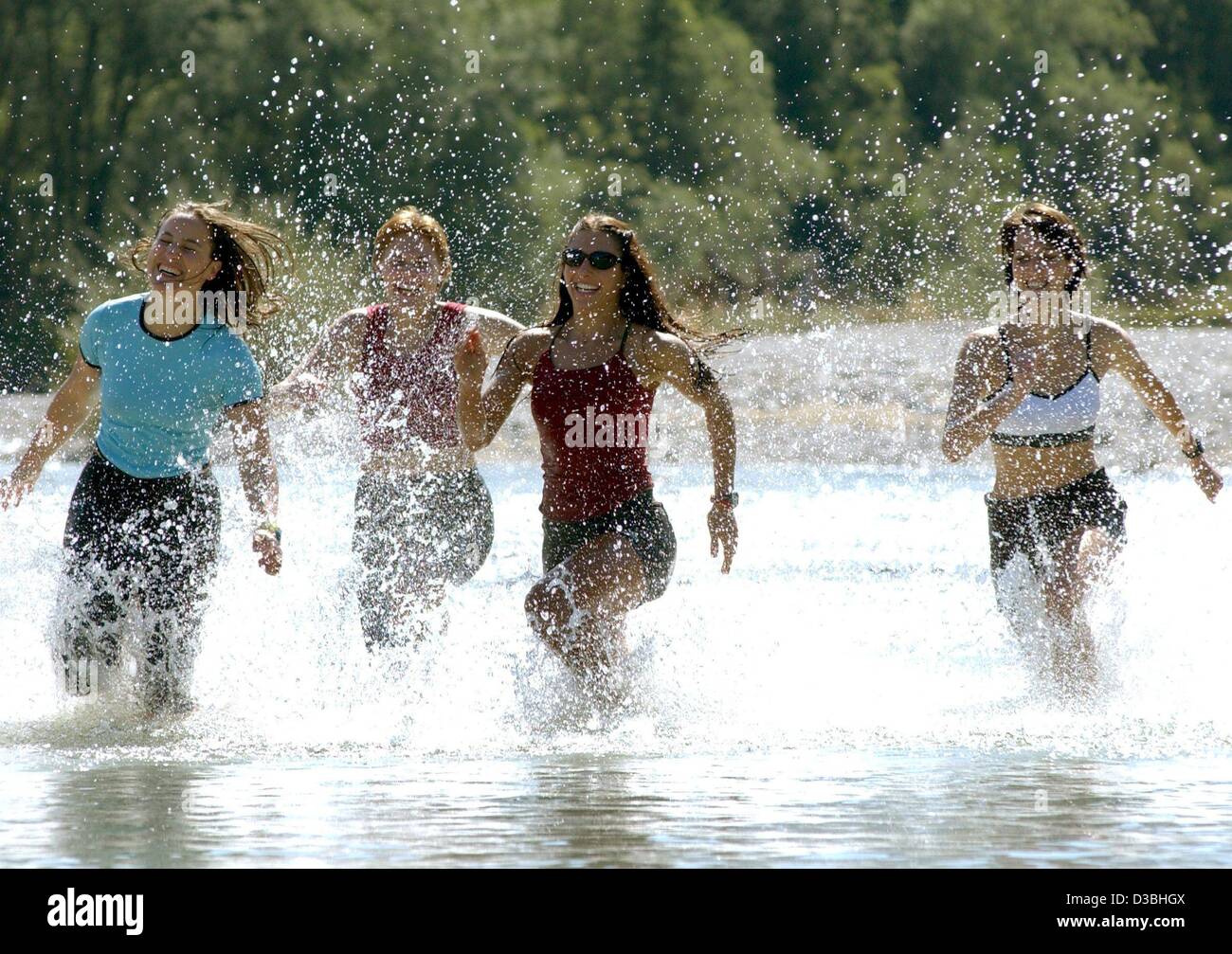 (dpa) - A group of women run splattering through the water of the River Isar in Lenggries, Germany, 5 June 2003. No matter what, with street wear through the river, as long as the cold water guaranties for cooling. Stock Photo