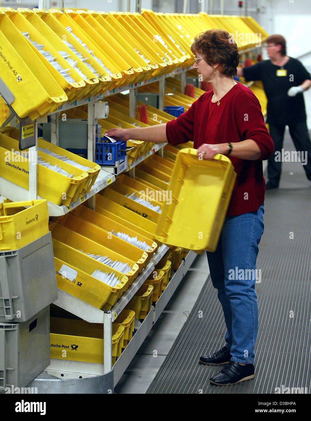 (dpa) - Two employees of the Deutsche Post AG sort letters at the letter center in Duesseldorf, Germany, 27 January 2003. The company has 83 national letter centers and an international post center. Daily about 72 million letters are sorted and mailed. Stock Photo