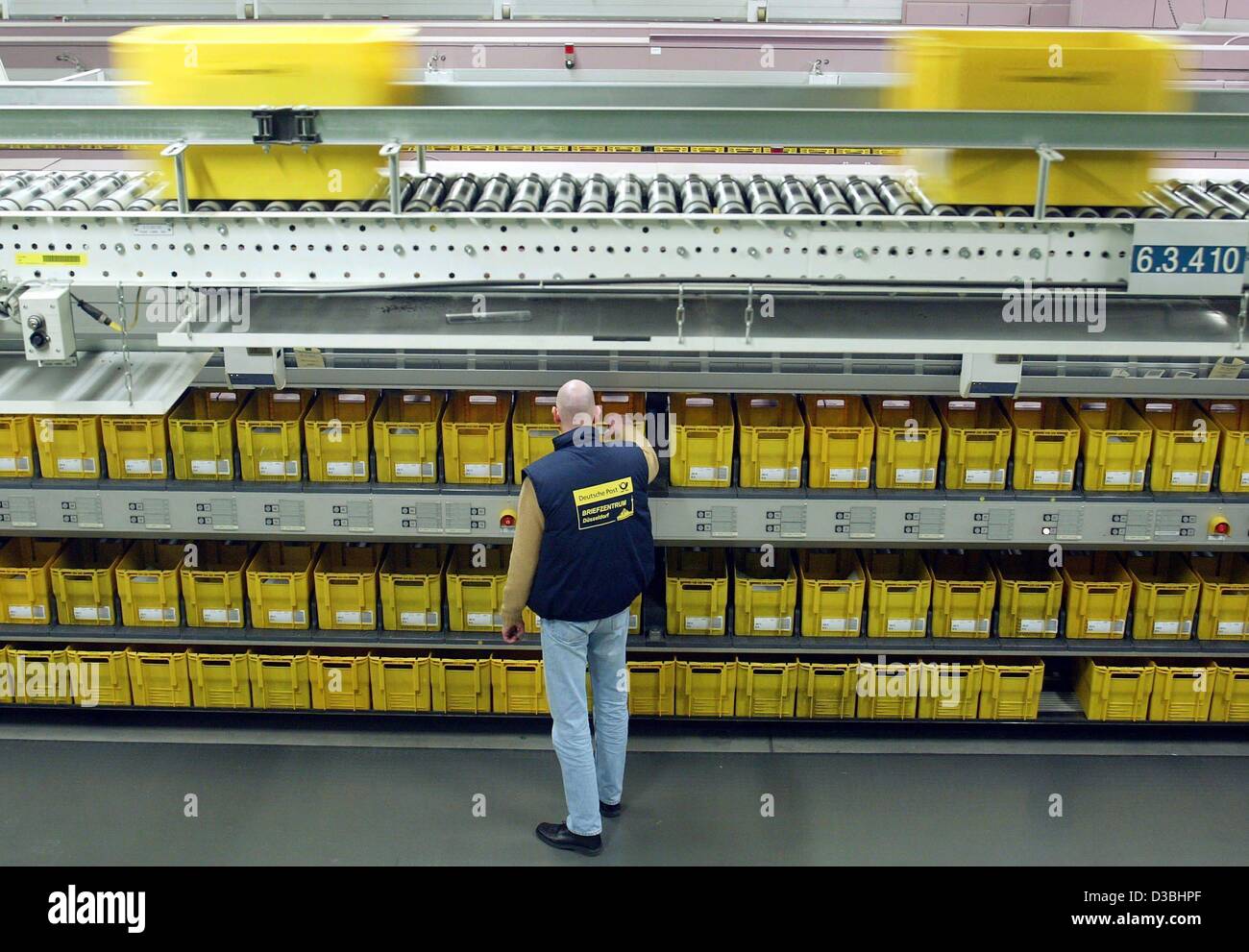 (dpa) - An employee of the Deutsche Post AG operates a machine at the letter center in Duesseldorf, Germany, 27 January 2003. The company has 83 national letter centers and an international post center. Daily about 72 million letters are sorted and mailed. Stock Photo
