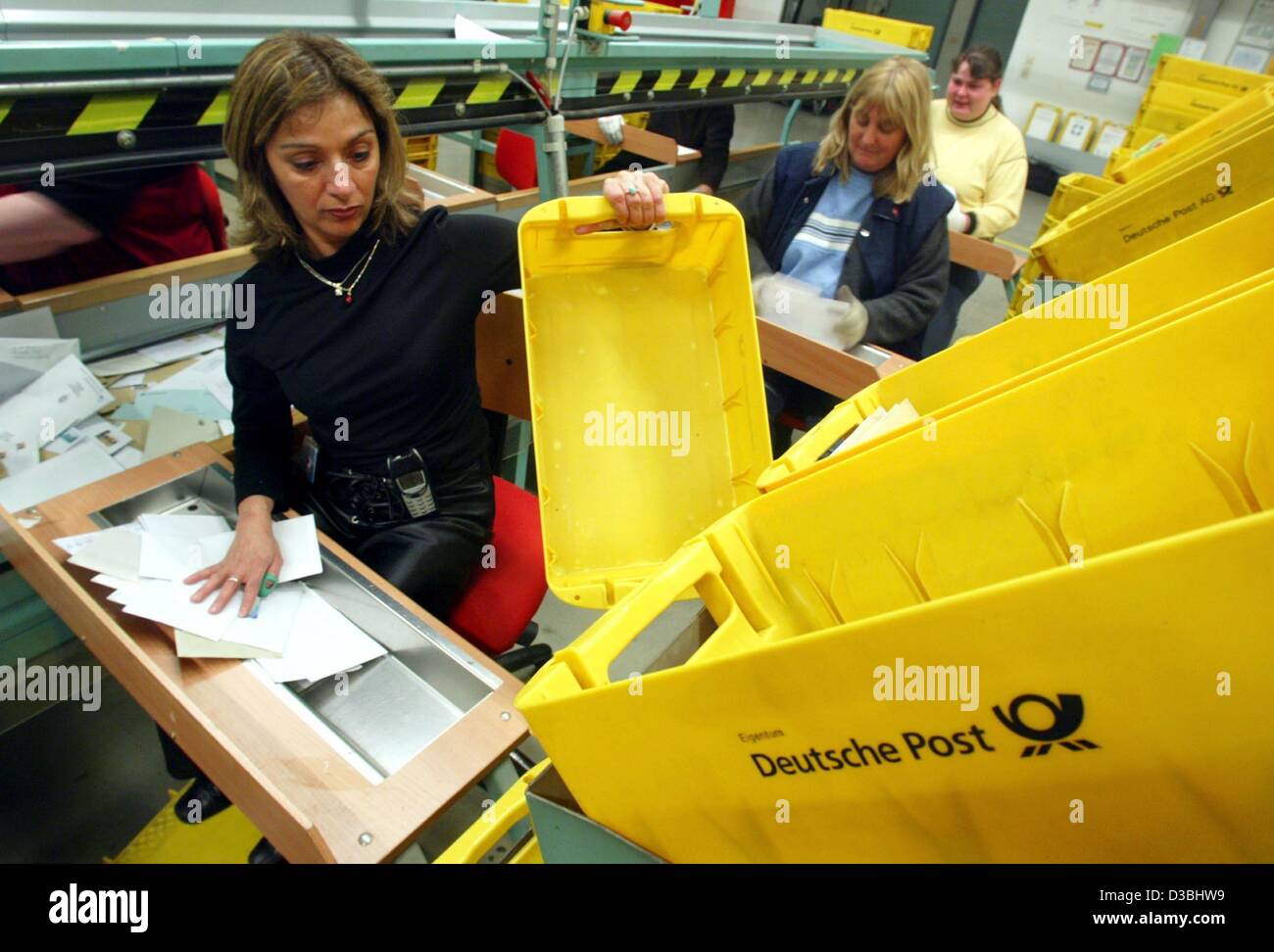(dpa) - An employee of the Deutsche Post AG empties a yellow box in order to sort the letters at the letter center in Duesseldorf, Germany, 27 January. The company has 83 national letter centers and an international post center. Daily about 72 million letters are sorted and mailed. Stock Photo