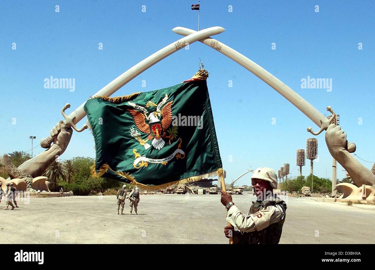 (dpa) - A US soldier flies the flag of the 504th Military Police squad in front of the Celebration Square monument in Baghdad, 1 May 2003. Stock Photo