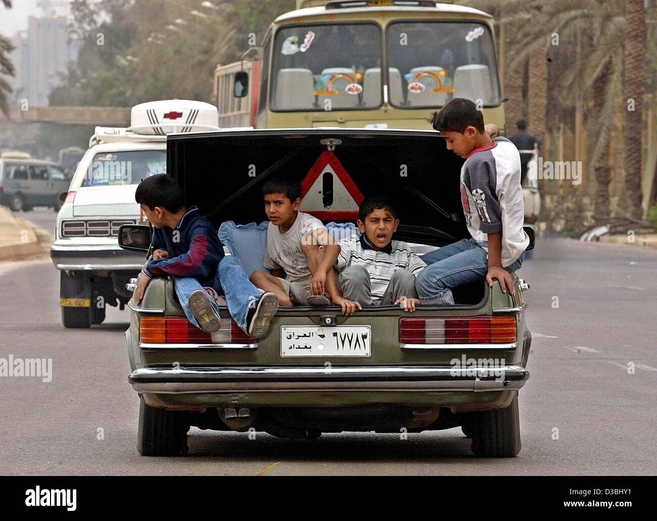 (dpa) - Iraqi boys sit in a car boot on the streets of Baghdad, 15 April 2003. Stock Photo
