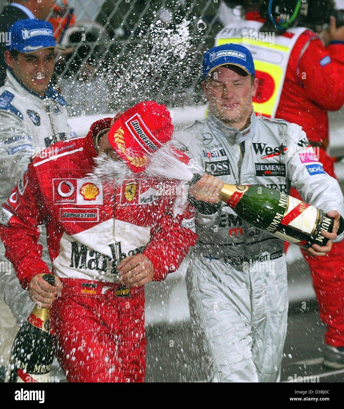 (dpa) - The three first-placed winners of the formula one Grand Prix of Monaco celebrate with champagne in Monte Carlo, 1 June 2003. Colombian Juan Pablo Montoya of BMW Williams (back) takes first place, Finnish Kimi Raekkoenen (R, McLaren Mercedes) finishes second and German world champion Michael  Stock Photo