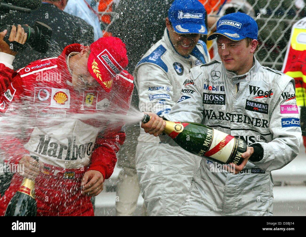 (dpa) - The three first-placed winners of the formula one Grand Prix of Monaco celebrate with champagne in Monte Carlo, 1 June 2003. Colombian Juan Pablo Montoya of BMW Williams (C) takes first place, Finnish Kimi Raekkoenen (R, McLaren Mercedes) finishes second and German world champion Michael Sch Stock Photo
