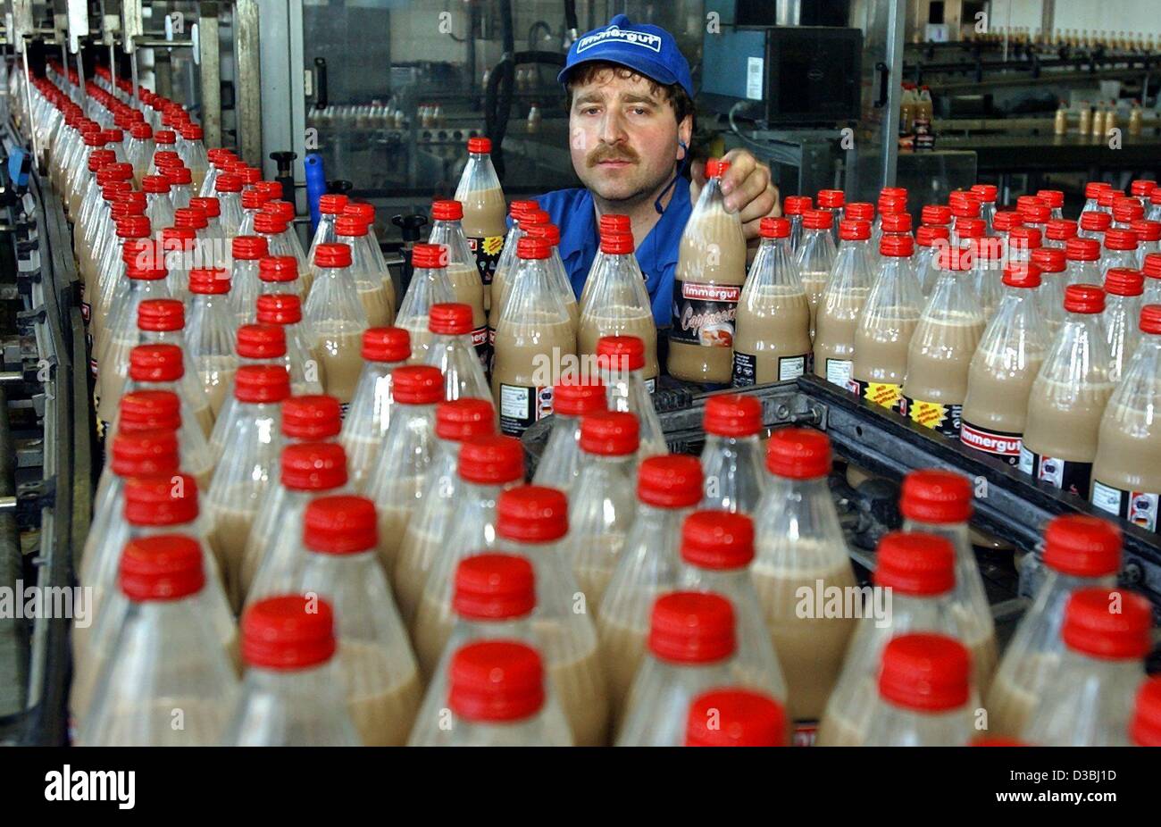 (dpa) - An employee of Immergut is checking bottles with chocolate milk on a conveyor belt, Stavenhagen, Germany, 2 April 2003. The dairy was founded in 1883 as a cooperative by 13 local farmers and recently celebrated its 120th anniversary. The 'Treuhand' privatisation agency wanted to close the en Stock Photo