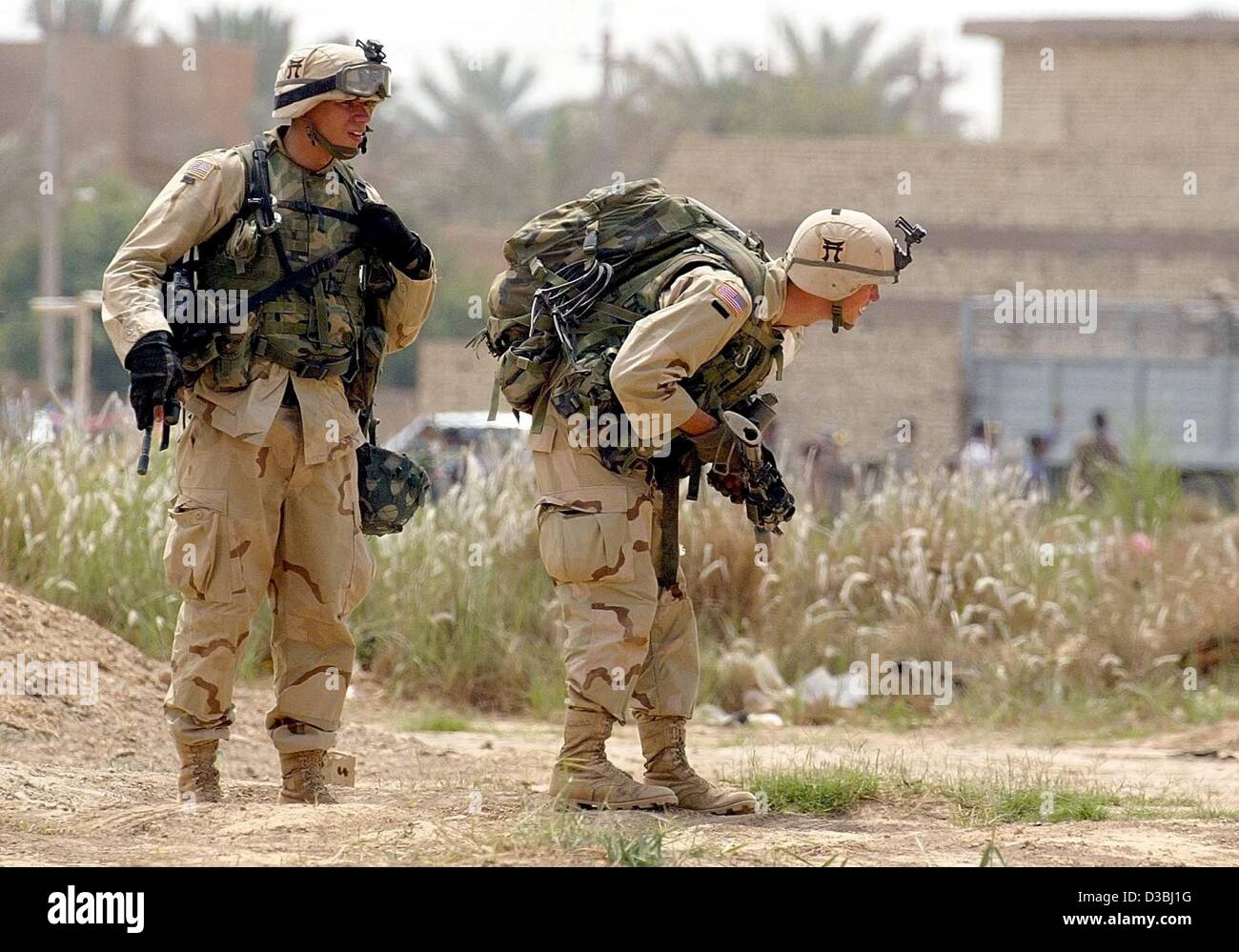 (dpa) - US soldiers search for an unexploded ordnance in a suburb of Baghdad, Iraq's capital, 24 April 2003. Stock Photo