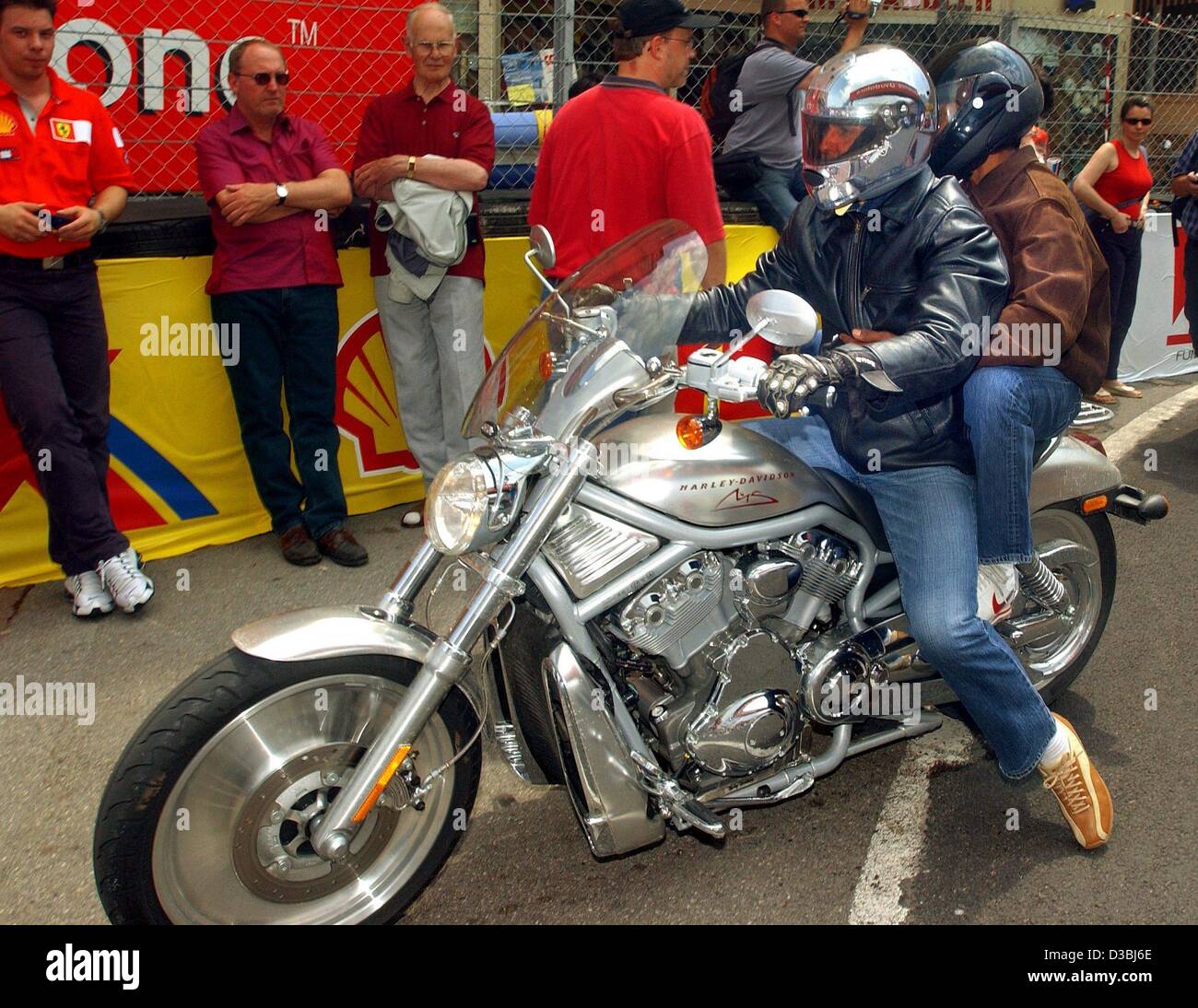 (dpa) - German Formula 1 champion Michael Schumacher (driver, Ferrari) and his physiotherapist Balbir Singh are on their way to the drivers camp on a Harley Davidson in Monaco, 28 May 2003. In casual clothes and with a helmet on his head only few fans recognize the Formula 1 star. This Sunday 1 June Stock Photo