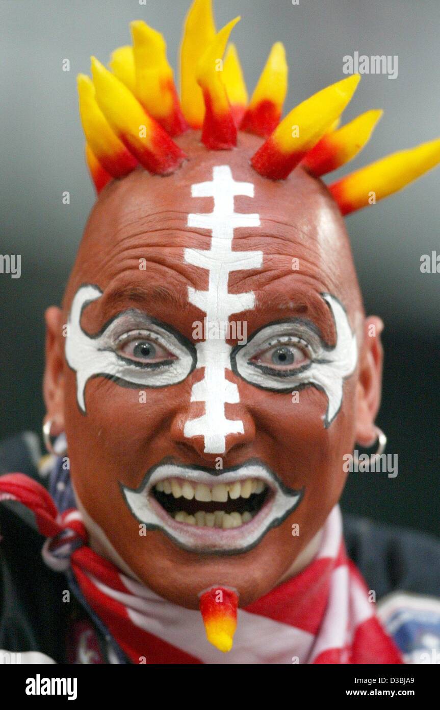 (dpa) - A fan with his face painted as a football and yellow-red devil-like spikes on his head and chin shouts encouragement at his favourite American football team Rhein Fire Duesseldorf during the NFL Europe game in Gelsenkirchen, Germany, 3 May 2003. Stock Photo