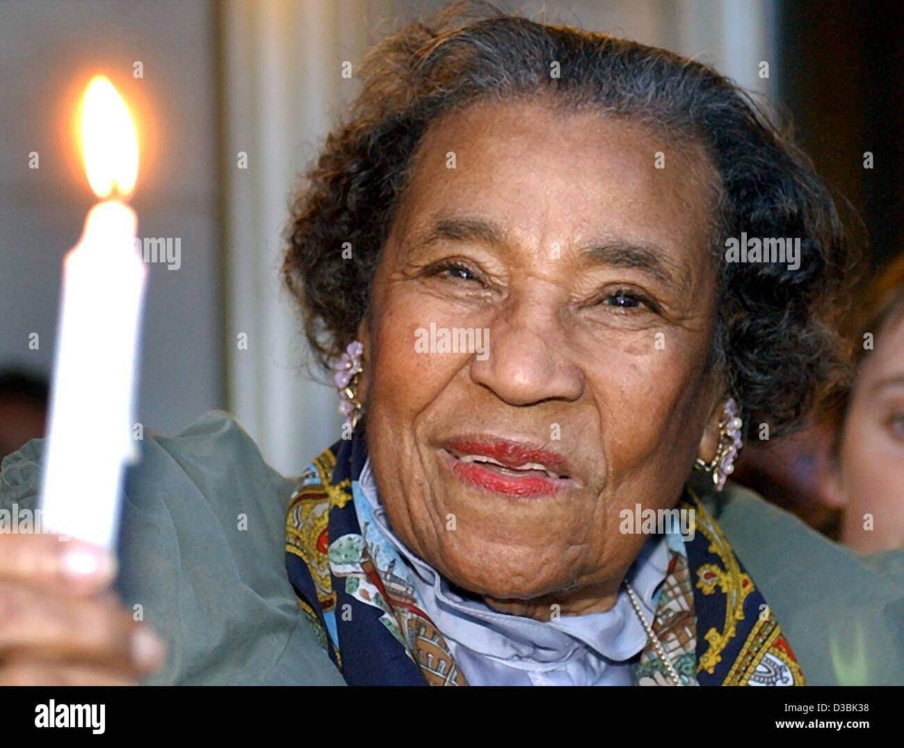 (dpa) - US civilrights activist 93-year-old Amelia Robinson, who has also worked with civilrights leader Martin Luther King, holds a candle in her hand and participates in the prayer for peace and the subsequent peace ralley at the Nikolai Church in Leipzig, Germany, 31 March 2003. According to orga Stock Photo