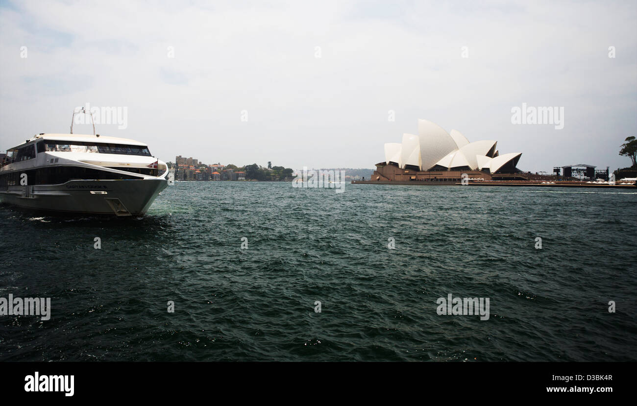 The 'Sydney Explorer' coming in to Circular Quay with the Sydney Opera House on a dull day in Sydney Cove. Stock Photo