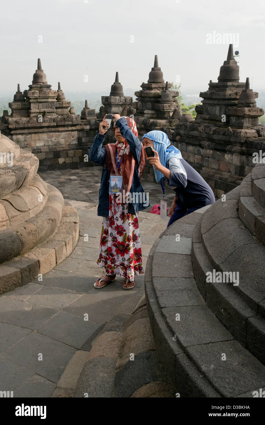 Two friends take photos at the Borobudur Buddhist Temple in Java, Indonesia Stock Photo