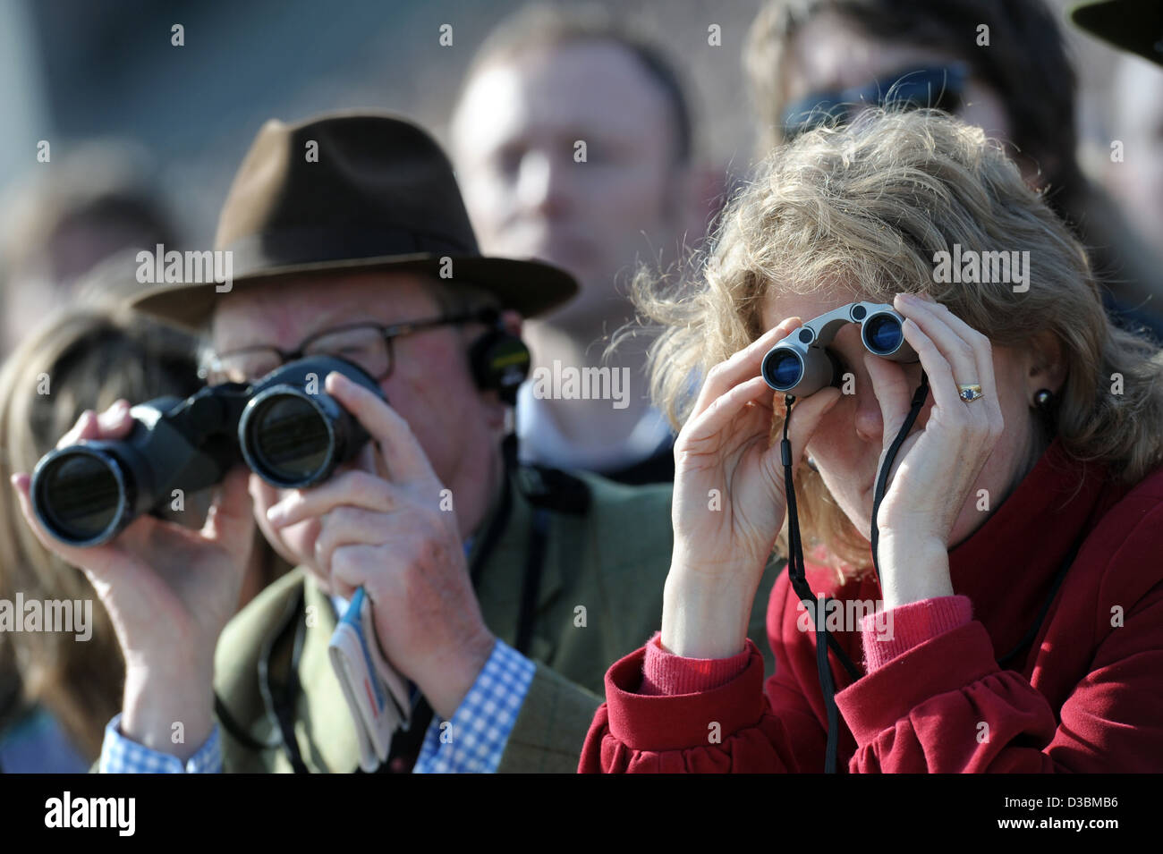 People watch the races through binoculars during the Cheltenham