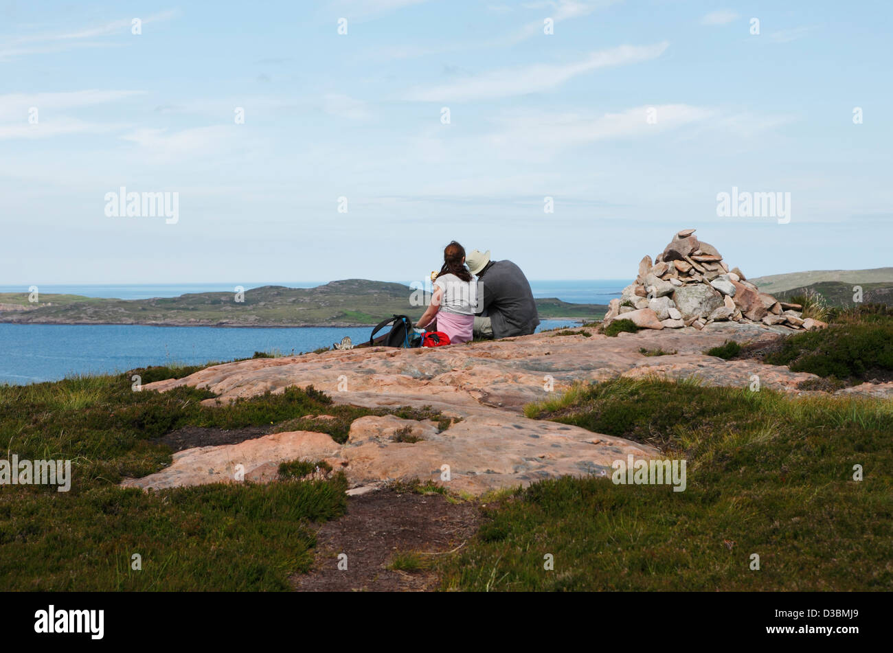 A high point on Tanera Mor, two people take a break looking out over the sea Stock Photo