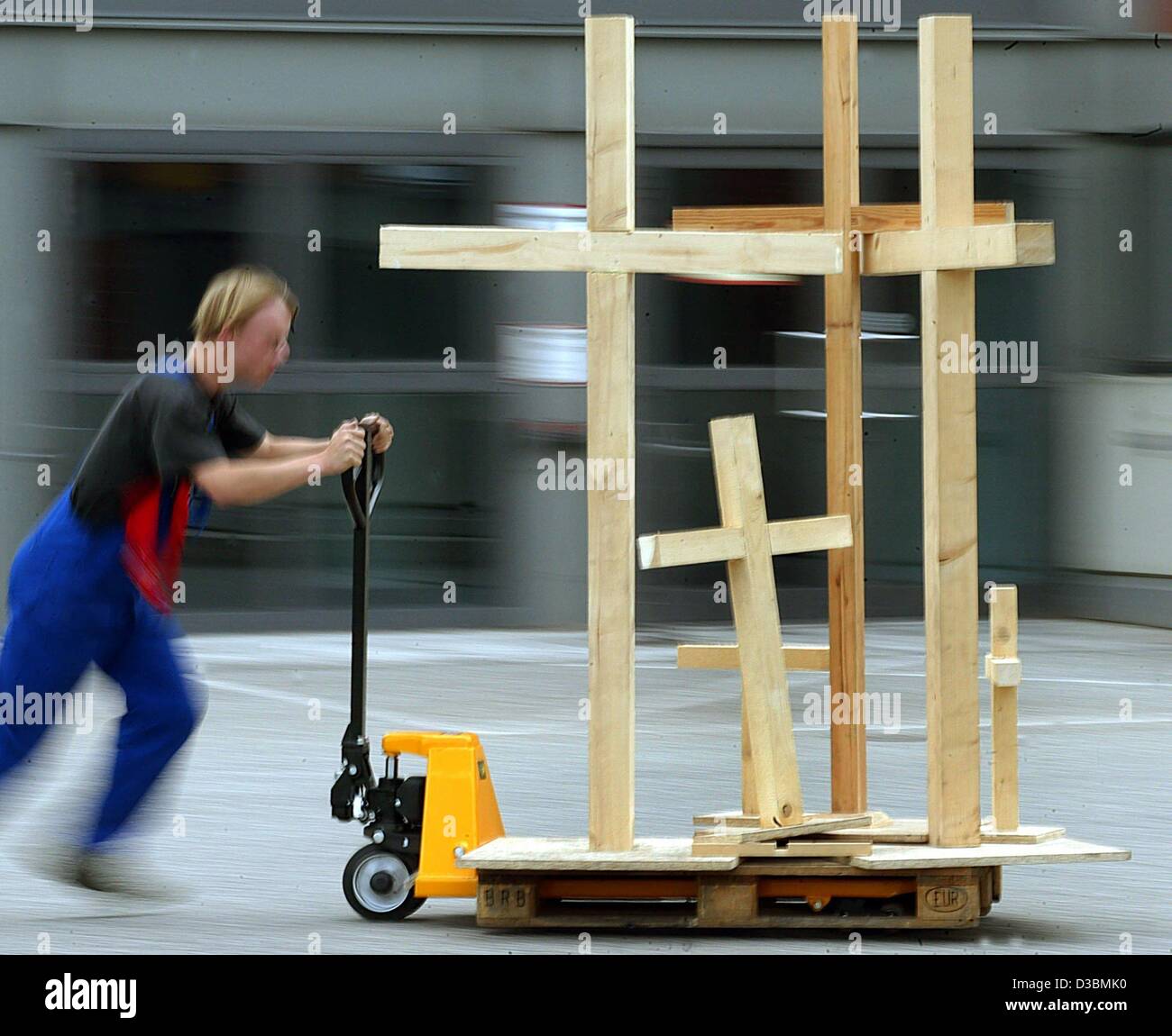 (dpa) - A worker rushes wooden crosses to the venue where the oecumenic church congress is to take place, in Berlin, 22 May 2003. About 200,000 participants are expected to take part in the church congress from 28 May to 1 June. Hotels in Berlin are already booked out during this period. Stock Photo
