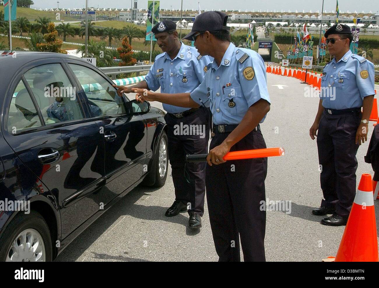 (dpa) - Malayan security forces conduct a security check on a car at the entrance to the formula one race track in Kuala Lumpur, Malaysia, 21 March 2003.  Security has been increased since the start of the war with Iraq. The formula one grand prix race in Malaysia is the second race of the season an Stock Photo