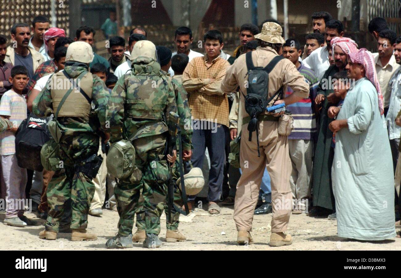 (dpa) - Iraqi civilians sceptically meet US Marines near Al Aziziyan about 40 km south of Baghdad, Iraq, 4 April 2003. While advancing towards the Iraqi capital the US troops are still waiting to be greeted by jubilating Iraqi civilians. Four days before the start of the war, the US vize president h Stock Photo