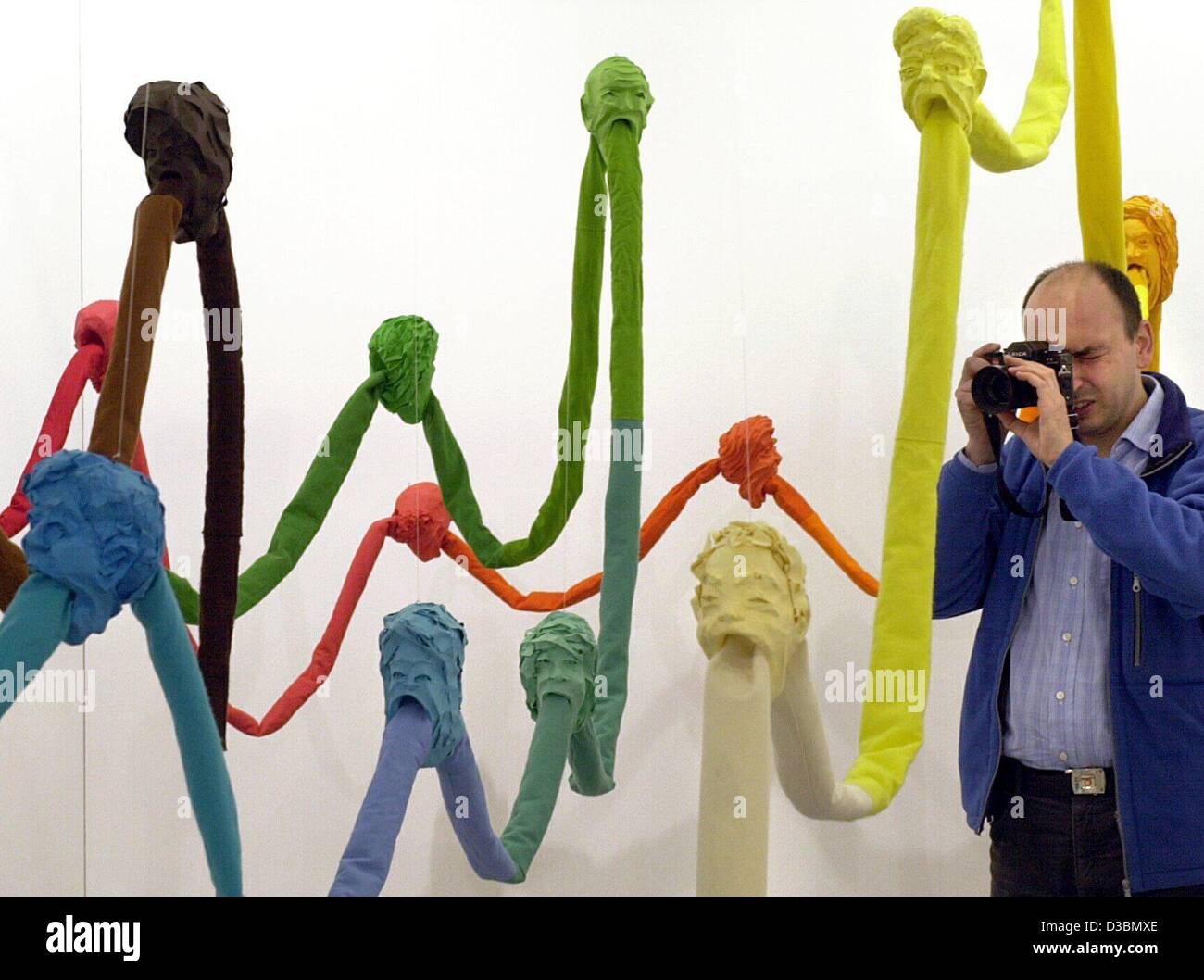 (dpa) - The German artist from Berlin Marcus Weber takes a picture of his sculpture 'Unersättlicher Kreislauf' (insatiable circuit) at the 15th Art Frankfurt, in Germany, 26 April 2003. Weber's sculpture is made of paper and sleaze, measures 20 metres and is offered for 22,000 Euros by the gallery H Stock Photo