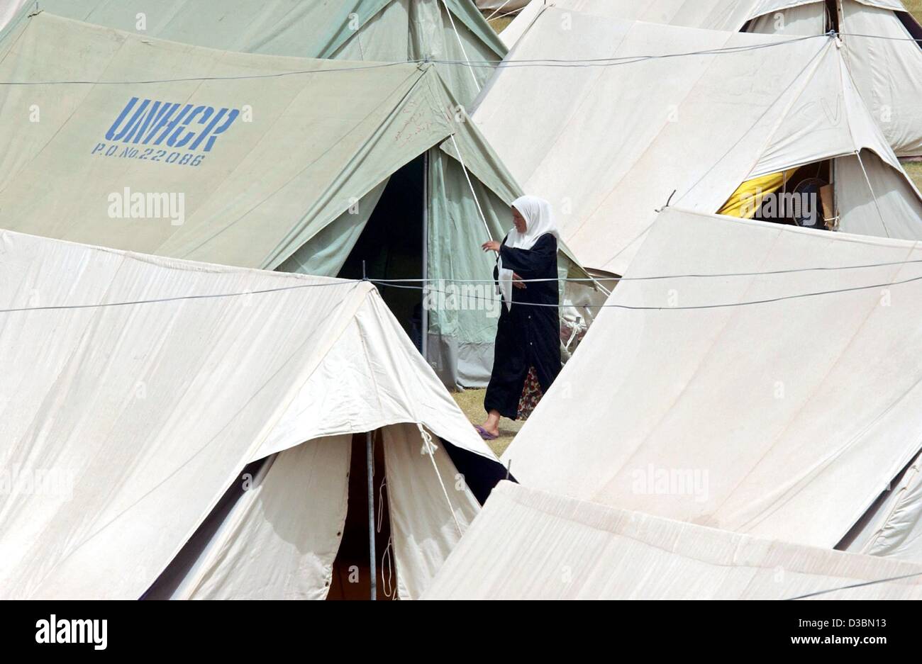 (dpa) - A Palestinian woman walks between tents in a UNHCR tent camp ...