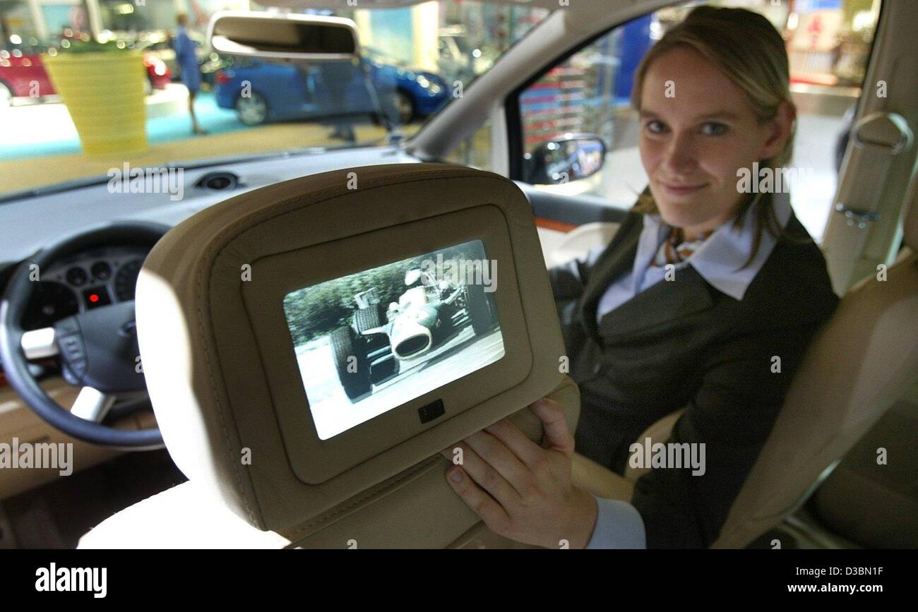 (dpa) - Annet Dau sits in the co-driver's seat and presents a video screen in the headrest of the driver's seat of a Ford Galaxis in an exhibition hall at the AMI (Auto Messe International) car exhibition fair in Leipzig, Germany, 4 April 2003. More than 415 exhibitor from 16 countries present the l Stock Photo