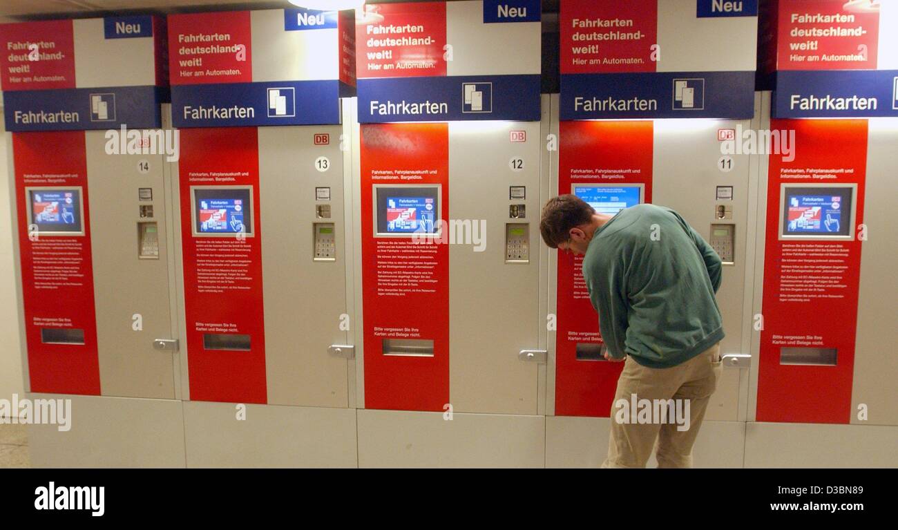 (dpa) - A traveller buys a railway ticket (Fahrkarten) from a ticket vending machine at the Bahnhof Zoo train station in Berlin, 20 May 2003. The German railway corporation Deutsche Bahn AG will reconsider their new price system for tickets, which was introduced last December. Since, the turnover in Stock Photo