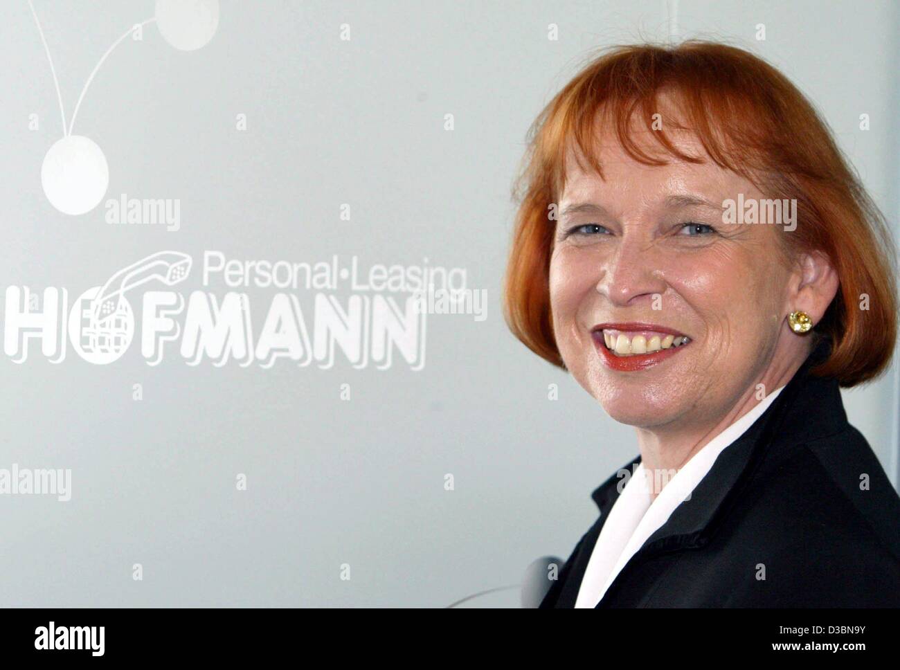 (dpa) - Ingrid Hofman, owner of the company Hofman Personal Leasing GmbH, smiles in front of her company's logo in Nuremberg, Germany, 20 May 2003. The 49-year-old businesswoman was awarded the Prix Veuve Clicquot for Entrepreneur of the Year 2002 in Munich. The Prix Veuve Clicquot is awarded every  Stock Photo