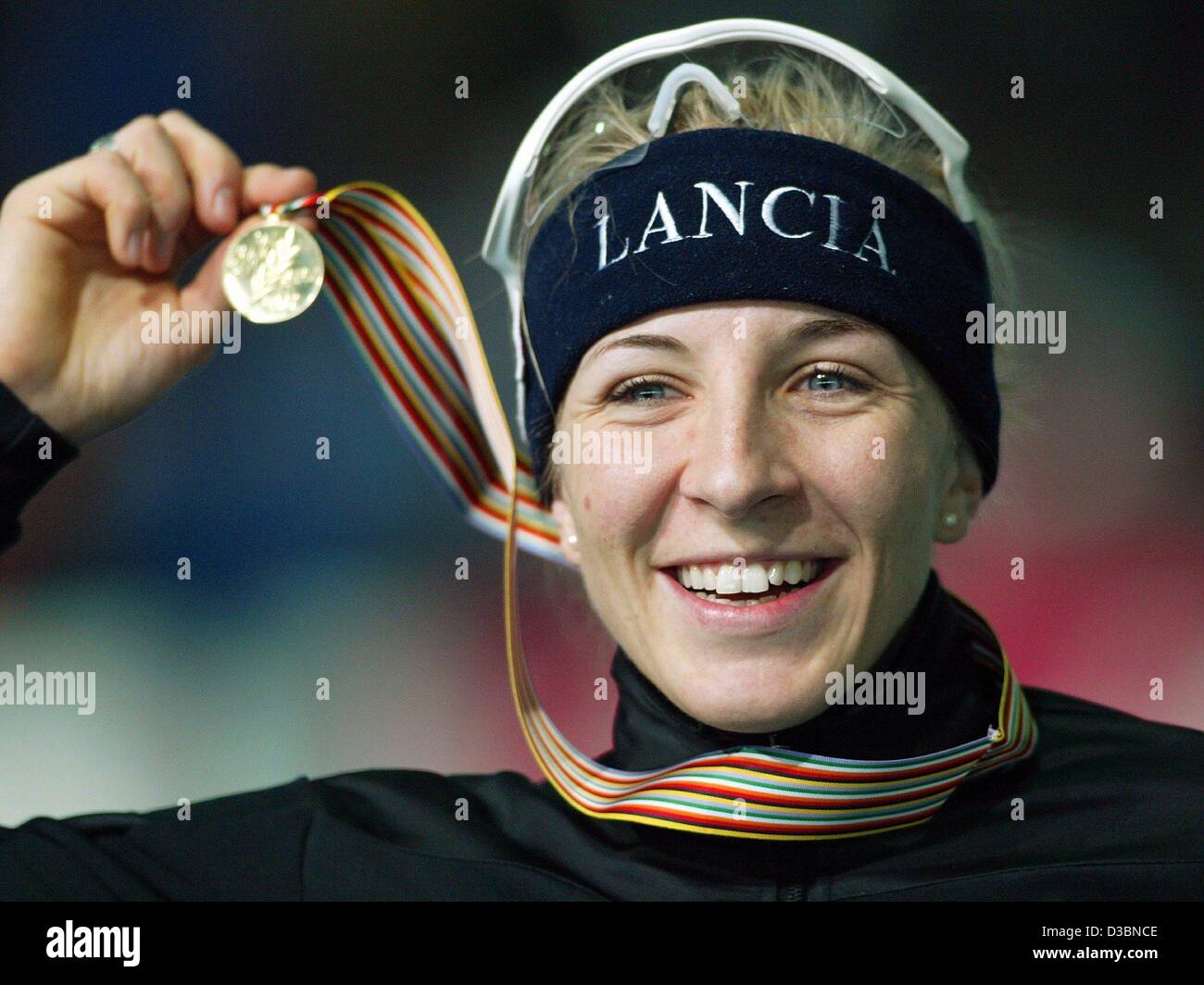(dpa) - German speed skater Anni Friesinger smiles and gestures and presents her medal after speeding down the ice track in the women's 1500 meter race at the Speed Skating World Championship in Berlin, 14 March 2003. Friesinger runs the distance in 1:57,43 minutes and wins the world champion title. Stock Photo