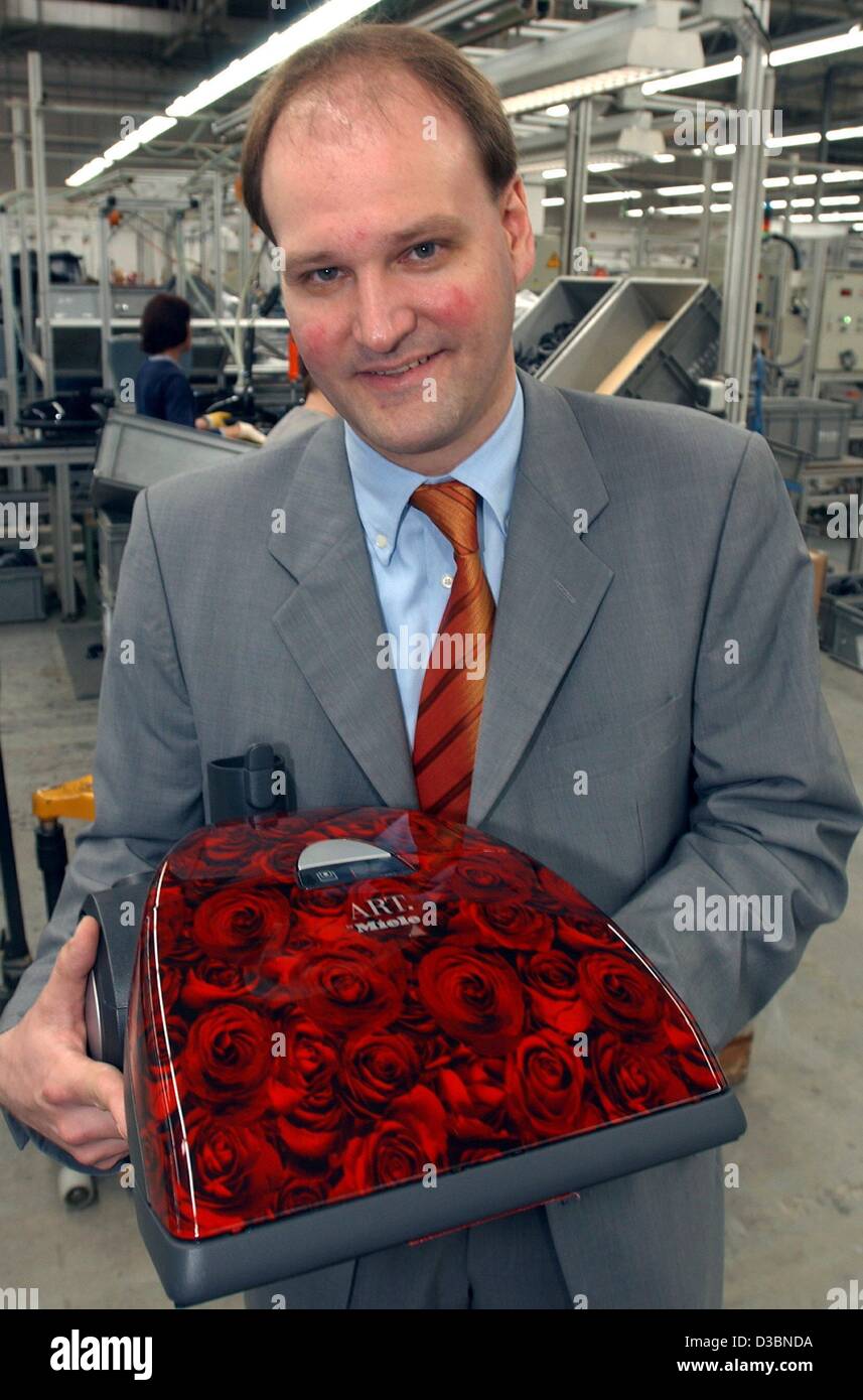 (dpa) - Markus Miele, director of Miele KG, presents a vacuum cleaner with a red rose design, Bielefeld, Germany, 3 April 2003. The multi purpose vacuum cleaner is available in five designs. Miele produces 1.5 million vacuum cleaners per year, more than any other European company. Apart from this, d Stock Photo