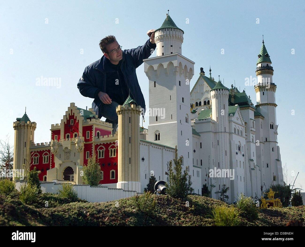 (dpa) - Model maker Ilja Schueler puts the finishing touches on the model of Neuschwanstein Castle built of Lego bricks in Legoland near Guenzburg, Germany, 8 April 2003. The Danish toy group Lego invested roughly 150 million Euro to build its fourth amusement park worldwide, which opened in 2002. T Stock Photo
