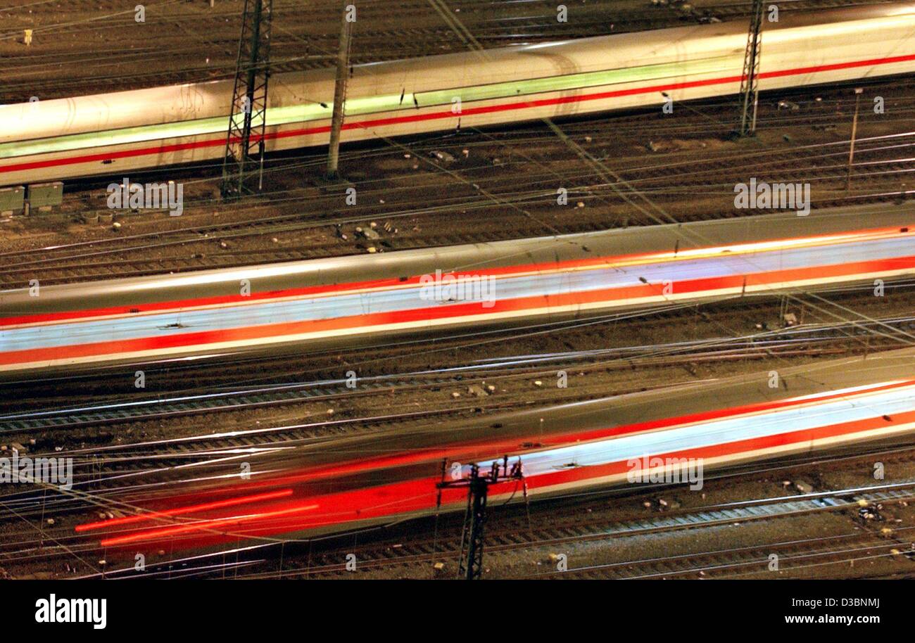 (dpa) - A ICE highspeed train, and two regional trains speed in opposite directions at the central station in Frankfurt, Germany, 8 March 2003. The effect was created by a long exposure time at dusk. Stock Photo