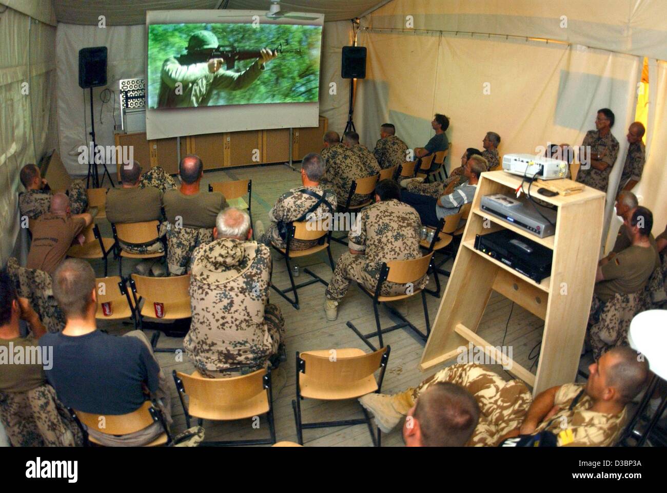 (dpa) - German soldiers sit in a tent in their spare time and watch the war film 'We were soldiers' in the German military camp 'Camp Warehouse' in Kabul, Afghanistan, 3 August 2003. Germany continues to participate with more than 1,500 soldiers in the International Securtiy Assistance Force (ISAF)  Stock Photo