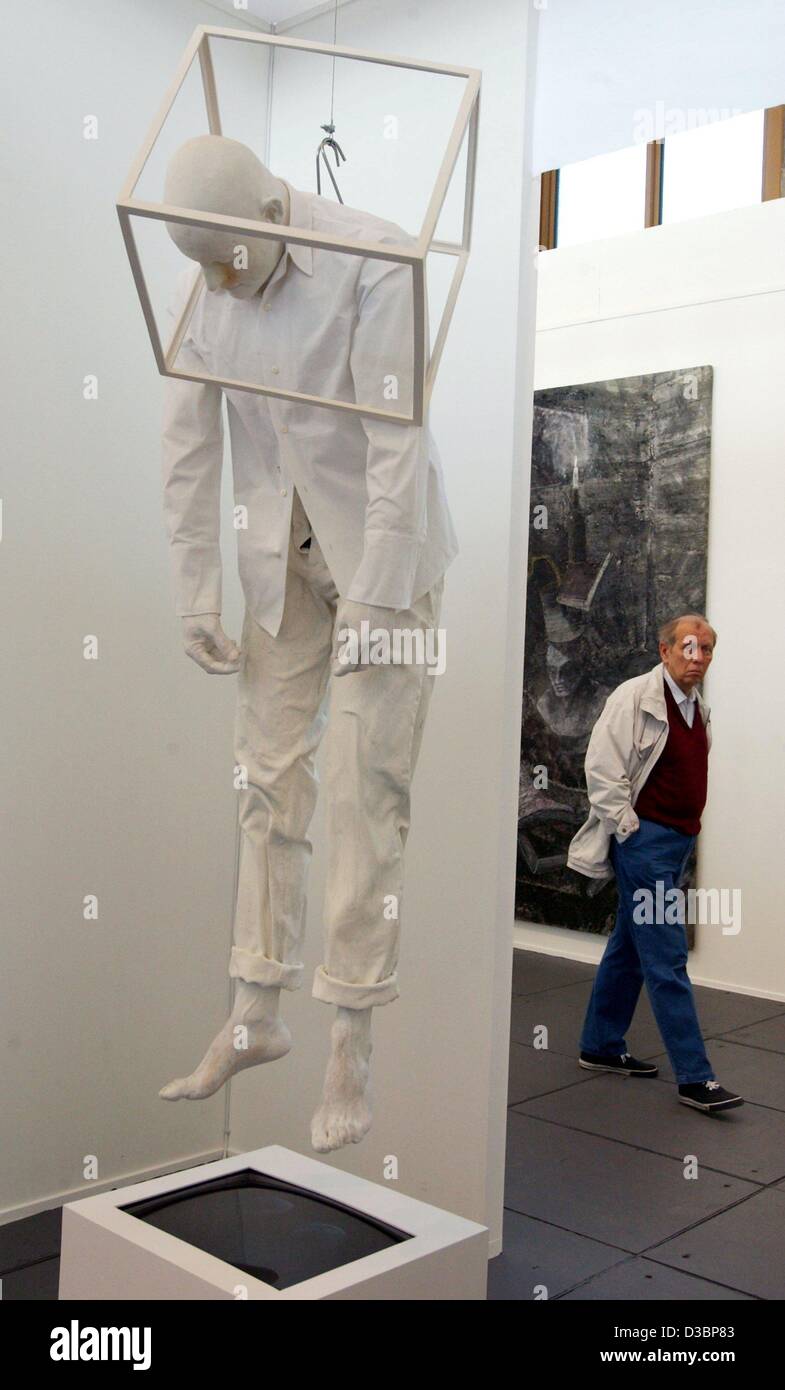 (dpa) - A visitor walks past a sculpture of Bernardi Roig, titled 'Reflection exercises', during the 8th Art Forum, the international trade fair for contemporary art, at the exhibition pavilion in Berlin, 1 October 2003. Around 1,100 artists from around the world exhibit their work of art and presen Stock Photo