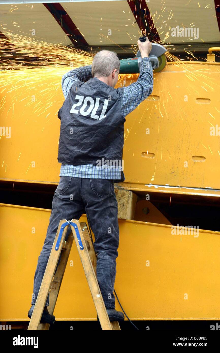 (dpa) - A customs (Zoll) worker cuts open excavator shovels which were seized on a Greek lorry, in Hamburg, 10 October 2003. The customs investigators found about 3.5 million smuggled cigarettes inside the shovels. The tax losses would have amounted to around 450 000 euros. Stock Photo