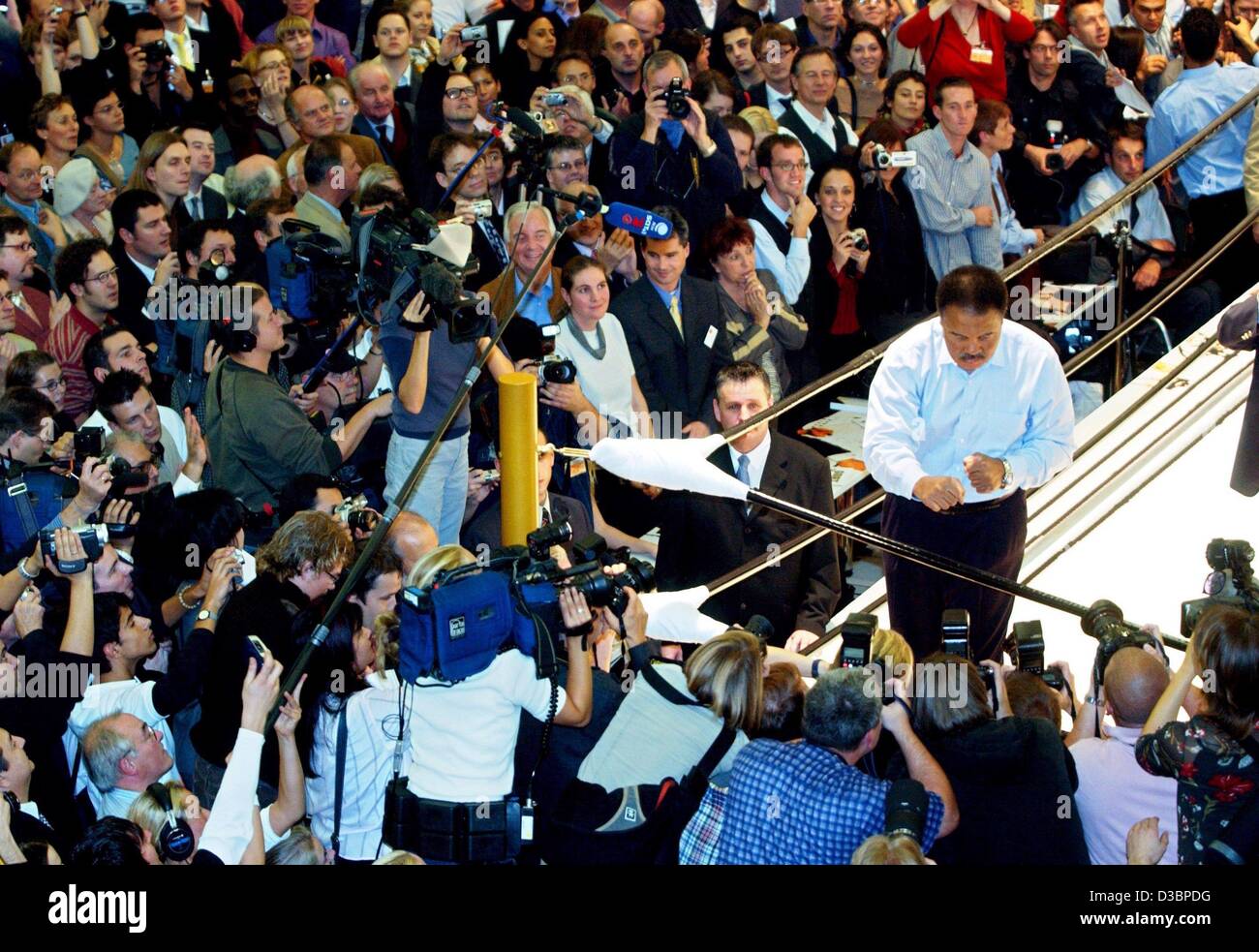 (dpa) - Journalists crowd around the ring where boxing legend Muhammad Ali presents his book at the book fair in Frankfurt, 9 October 2003. The book is entitled 'GOAT' (The Greatest Of All Times), costs 7500 Euro and weighs more than 30 kg. The boxer, who is marked by Parkinson disease, did not spea Stock Photo