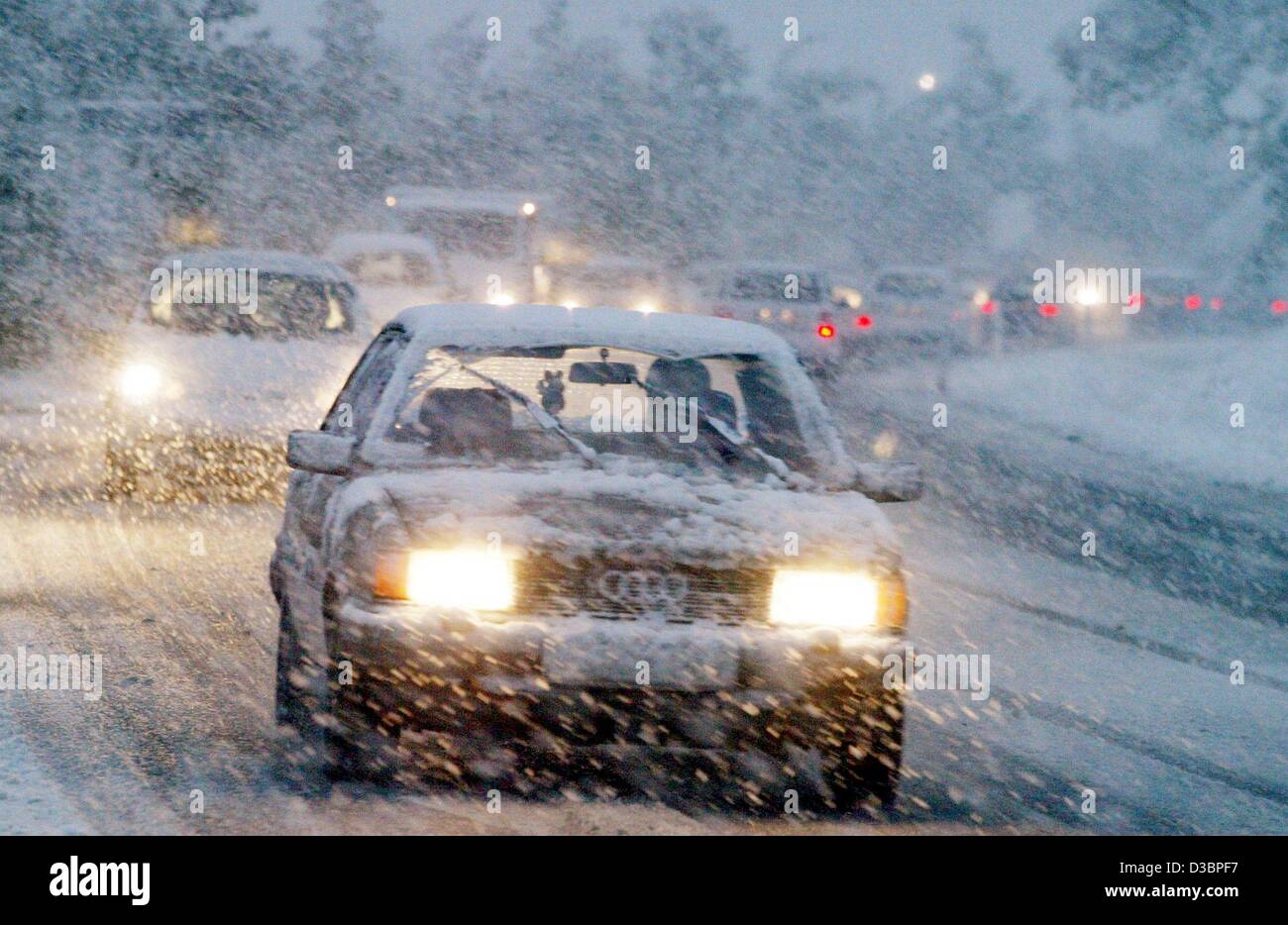 (dpa) - A column of cars moves slowly along a road admist a snow flurry in Villingen-Schwenningen, Germany, 7 October 2003. Strong winds and heavy snowfall have caused severe traffic congestions throughout the south of Germany. Numerous roads were closed due to crushing down trees and black ice incl Stock Photo