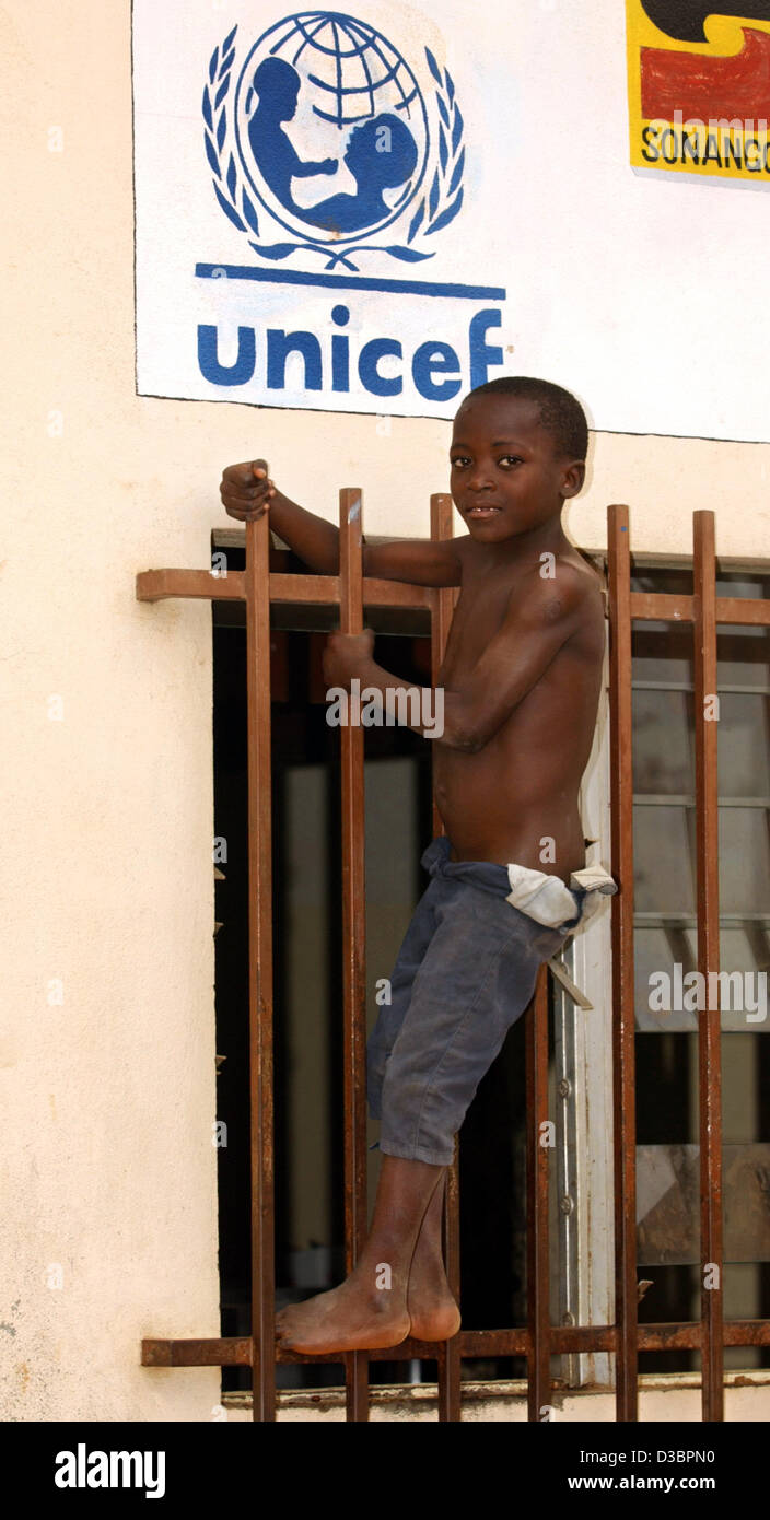 (dpa files) - Eight-year-old Augusto climbs a window grate in front of the 'Unicef' logo at the 'Centro Criancas Arnaldo Janssen', the centre for children who live on the streets by padre Horacia, in Luanda, the capital of Angola, 31 August 2003. Stock Photo