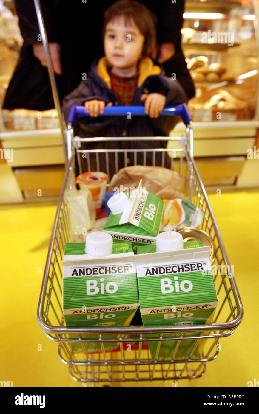 (dpa files) - A small child helps his mother push the shopping cart at ...