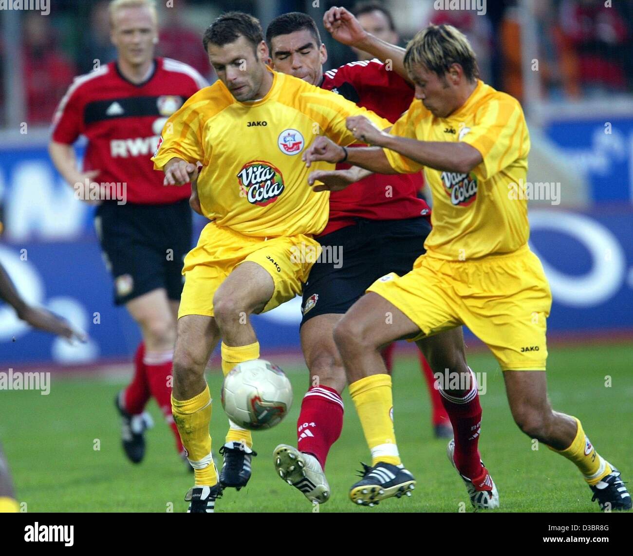(dpa) - Leverkusen's Lucio (C, red tricot) is attacked by Rostock's players Jochen Kientz (L) and Marcus Lantz (R) during the Bundesliga soccer game opposing Bayer Leverkusen and FC Hansa Rostock in Leverkusen, Germany, 5 October 2003. Leverkusen won 3-0 and now ranks second in the German first divi Stock Photo