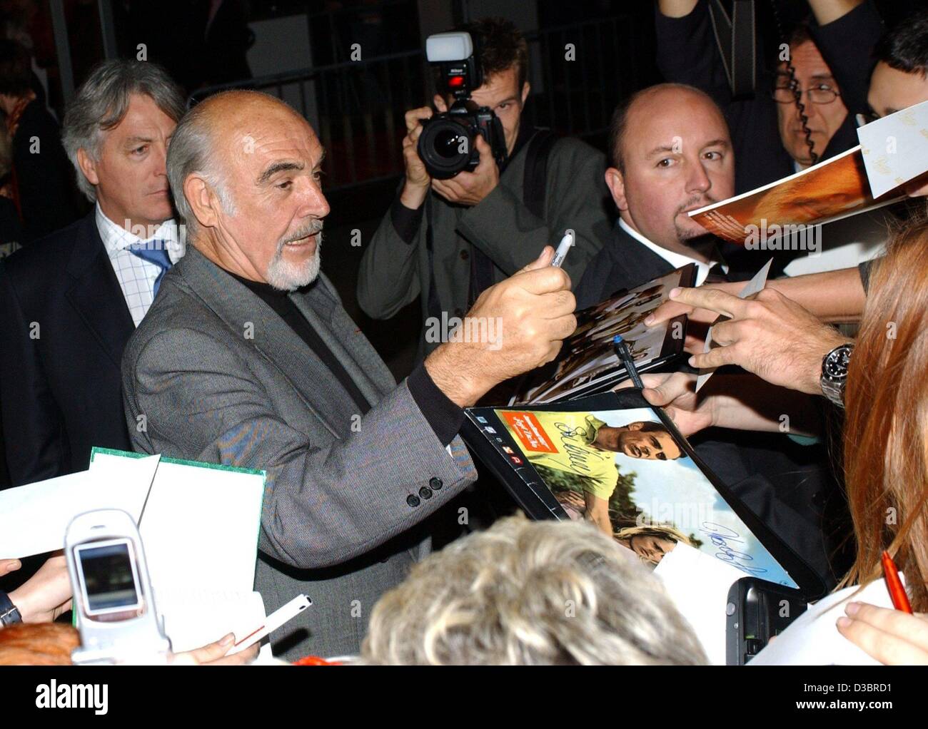 (dpa) - The Scottisch actor Sir Sean Connery ('James Bond', 'Name of the rose', 'The Rock', 'Finding Forrester') gives autographs at the premiere of his new film 'The Legue of Extraordinary Gentlemen' in Berlin, Germany, 30 September 2003. Numerous VIPs showed up at the event in the cinema 'Cosmos'. Stock Photo