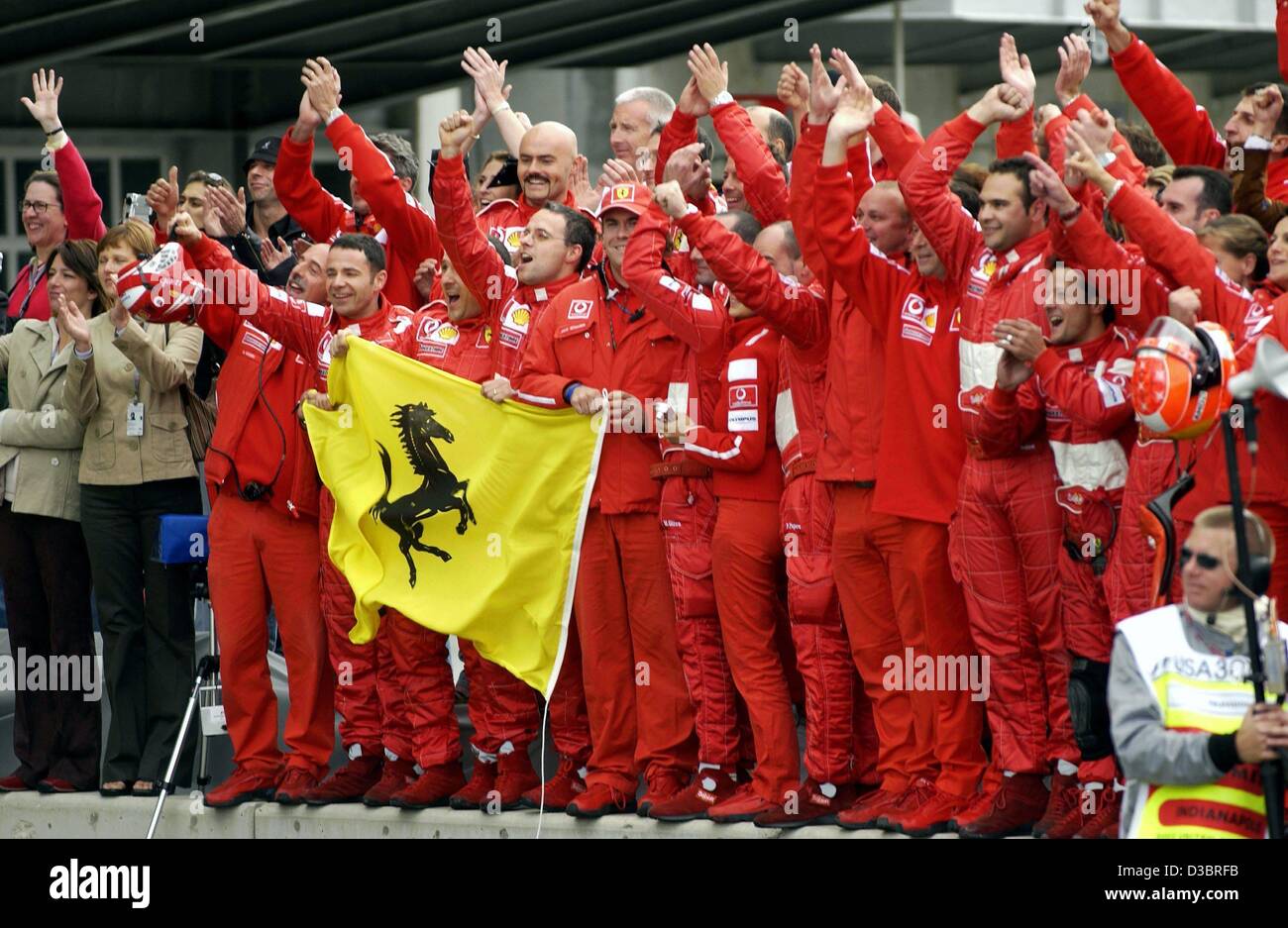 (dpa) - Team Ferrari salutes German Formula One world champion Michael Schumacher after he passes the chequered flag to win the US Grand Prix in Indianapolis, 28 September 2003. Schumacher won ahead of Finland's Kimi Raeikkoenen of McLaren-Mercedes and fellow German Heinz-Harald Frentzen of Sauber.  Stock Photo