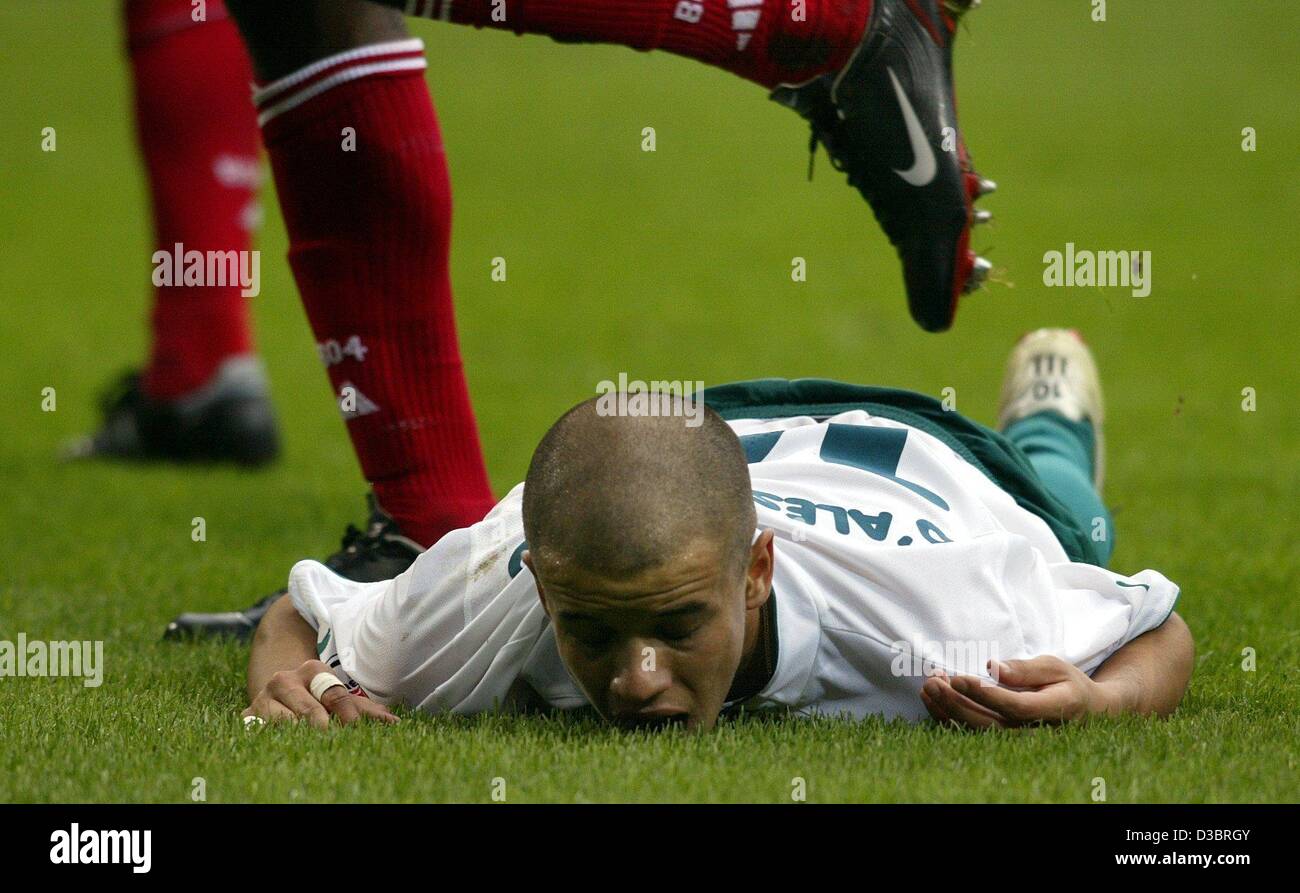 (dpa) - Wolfsburg's Argentine midfielder Andres d'Alessandro lies exhausted on the pitch as a pair of legs of a Leverkusen soccer player steps over him during the Bundesliga soccer game VfL Wolfsburg against Bayer 04 Leverkusen in Wlofsburg, Germany, 27 September 2003. Wolfsburg lost the game 0-1 ag Stock Photo