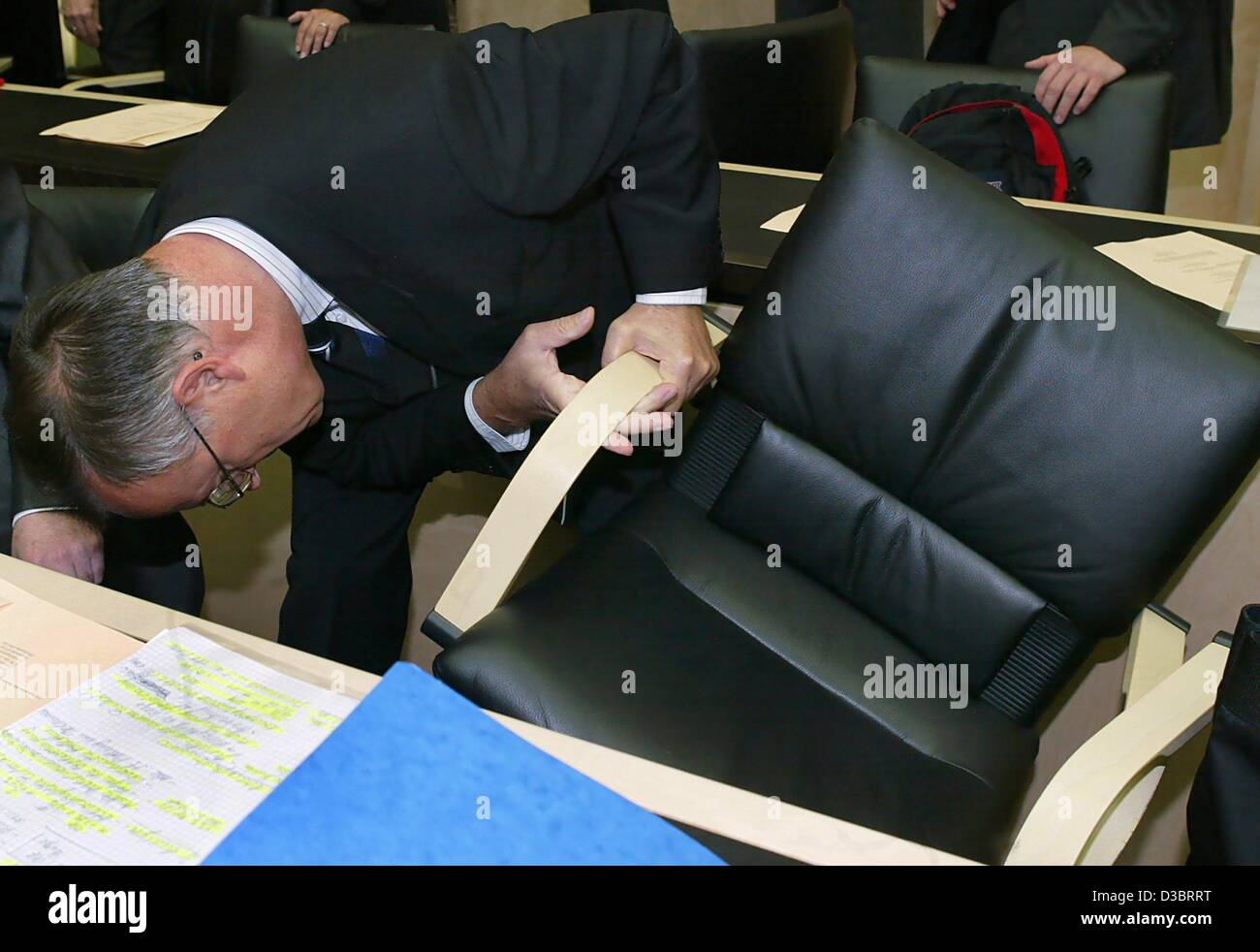 (dpa) - German Finance Minister Hans Eichel inspects the stableness of his chair ahead of a meeting in the Federal Council (Bundesrat) in Berlin, 26 September 2003. He delivered a speech on the budget 2004 and tax policies. Stock Photo