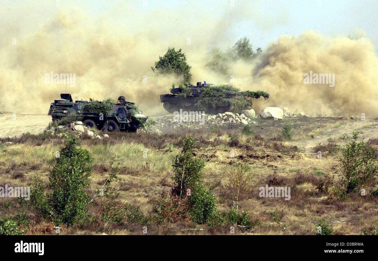 (dpa) - A tank and an armoured vehicle of the German armed forces (Bundeswehr) drive across a the Letzlinger Heath during an exercise near Letzlingen, Germany, 22 August 2003. The training is conducted for possible missions in international conflict areas. Stock Photo