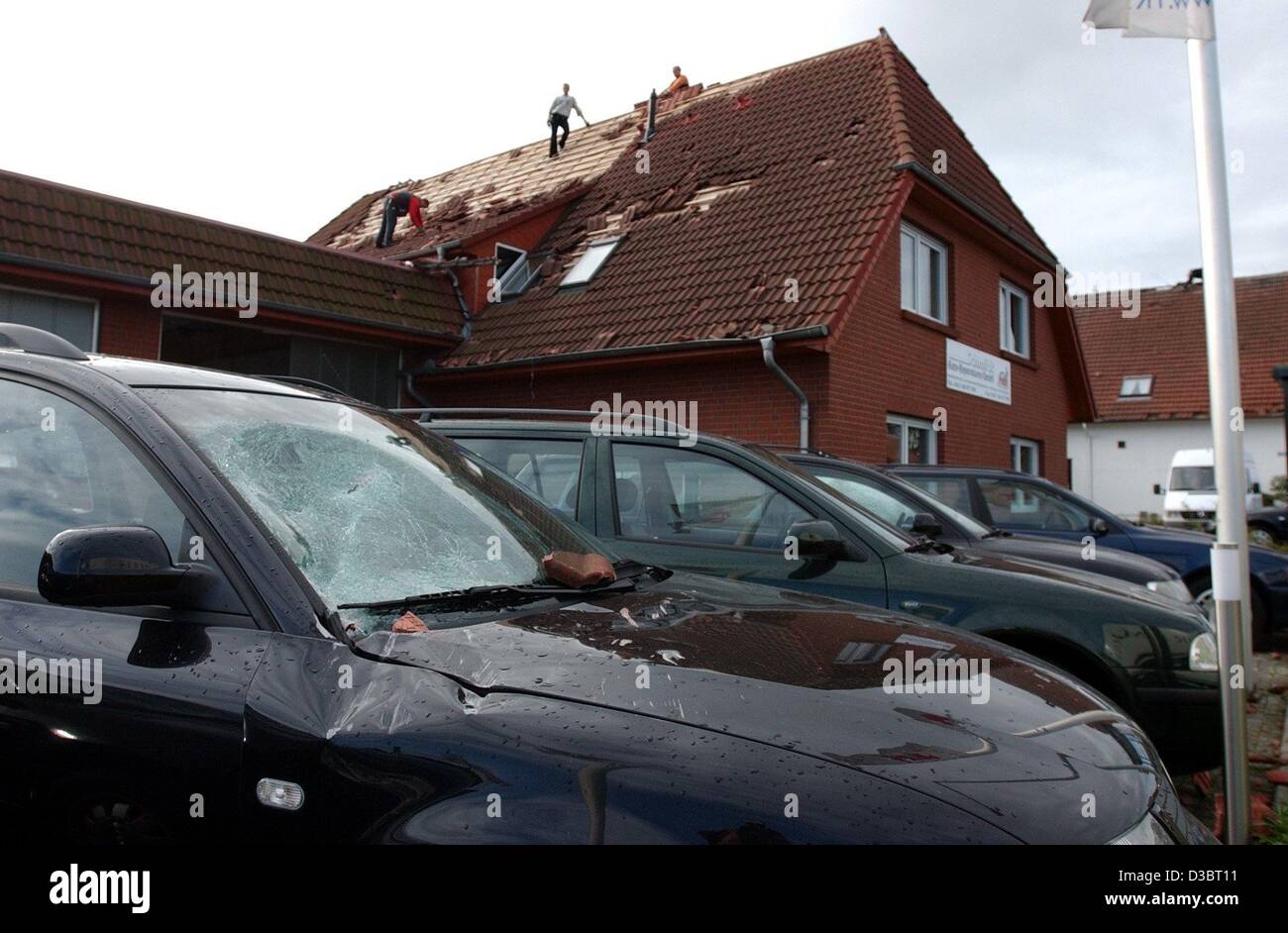 (dpa) - Several cars were severely damaged by falling rooftiles, at a car dealer's in Seckhausen, eastern Germany, 23 September 2003. The gale also lifted a small car, catapulting it against other vehicles. Storms and strong winds caused damages amounting to around a million euros in the region on T Stock Photo