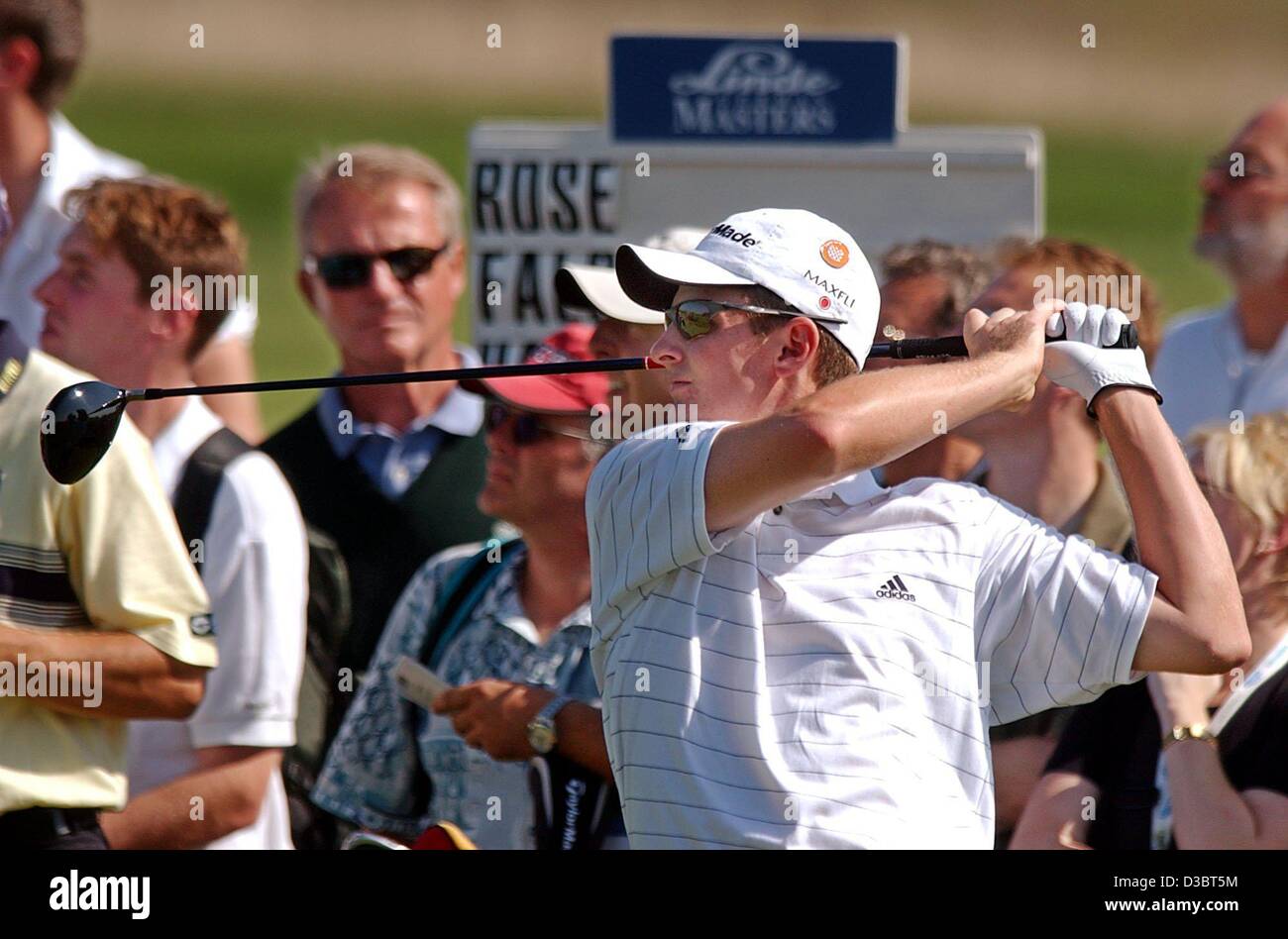 (dpa) - Golfer Justin Rose from Britain (front) and spectators watch his ball after tee off during the first round of the German Masters tournament in Pulheim near Cologne, Germany, 18 September 2003. Stock Photo