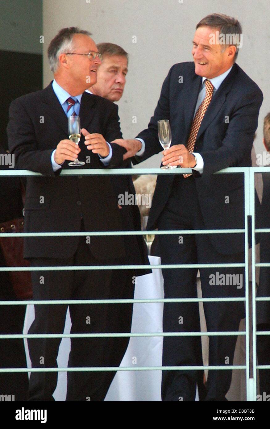 (dpa) - German Finance Minister Hans Eichel (L) holds a glass of champagne in his hand as he chats with his colleague French Minister of Finance Francis Mer (R) while behind them stands German Economy Minister Wolfgang Clement during a joint lunch on the balcony of the German Chancellery in Berlin,  Stock Photo