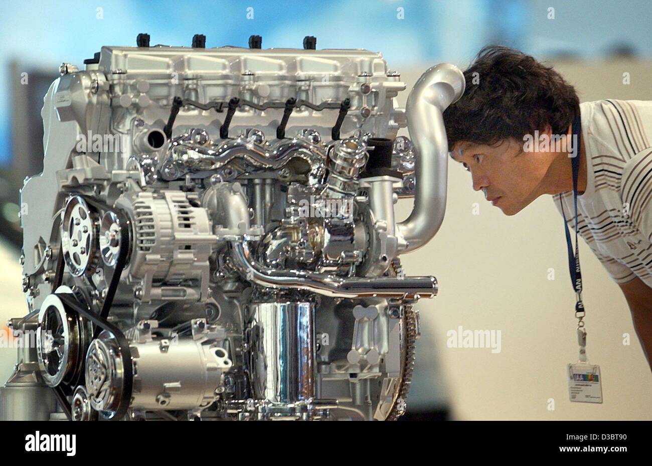 (dpa) - An employee of Japanese car maker Daihatsu inspects an engine, during the international auto show IAA in Frankfurt, Germany, 8 September 2003. From 12 September until 21 September the fair with around 1,000 exhibitioners from 42 countries is open for the public. About 850,000 visitors are ex Stock Photo