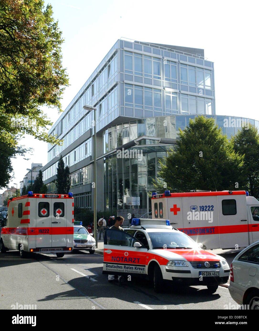 (dpa) - Several ambulance cars are parked outside a mail-order company, where a 24-year-old man attacked coworkers with a samurai sword, in Pforzheim, Germany, 16 September 2003. He killed one women and seriously wounded three others before plunging the weapon into himself. The police spokesman in t Stock Photo