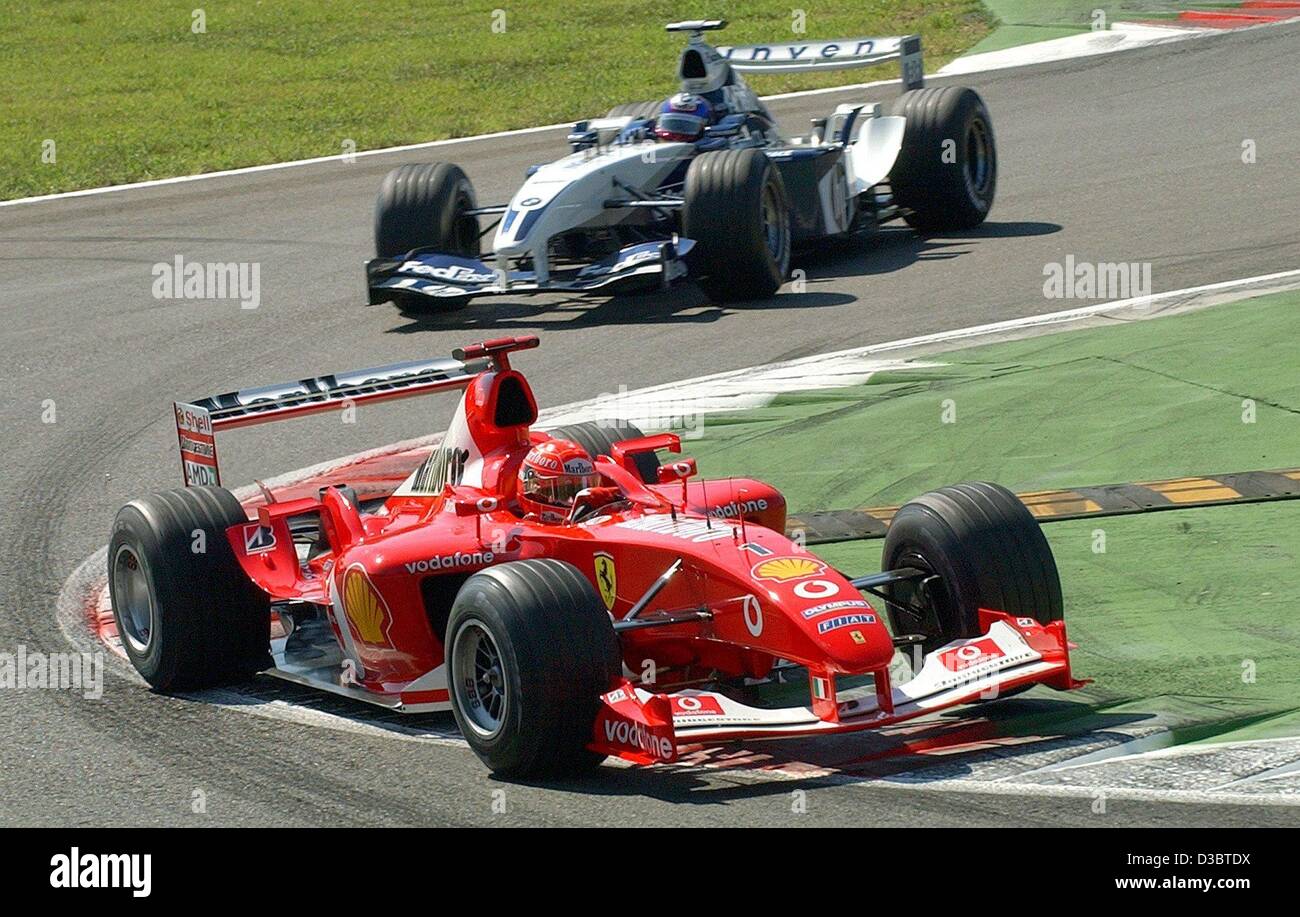 (dpa) - German formula one pilot Michael Schumacher of Ferrari (front) leads ahead of Colombian Juan Pablo Montoya (BMW-Williams) shortly after the start of the Grand Prix of Italy in Monza, 14 September 2003. Schumacher wins the race and leads the overall standings with 82 points, followed by Monto Stock Photo