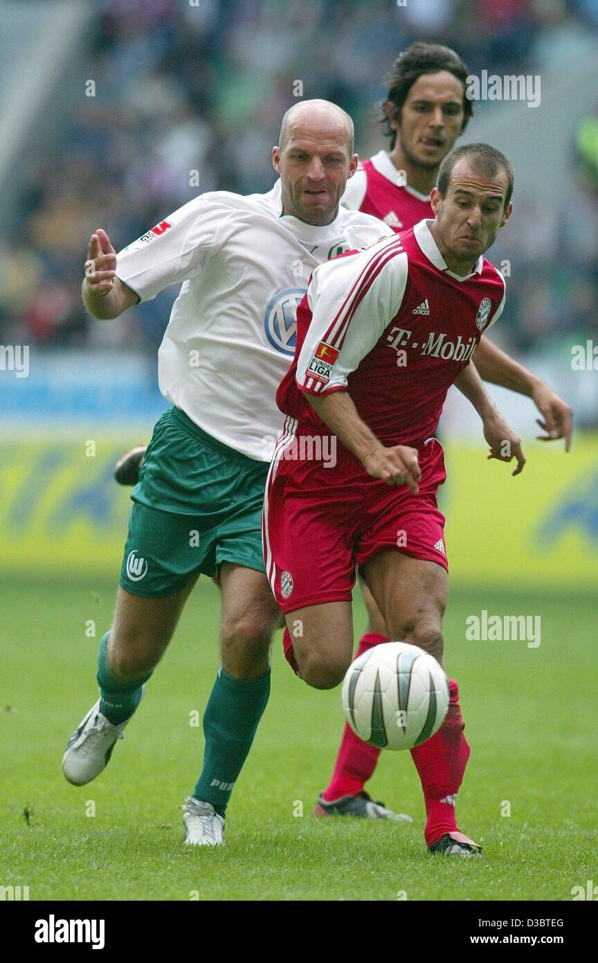 (dpa) - Bayern's midfielder Mehmet Scholl (R) vies for the ball with Wolfsburg's defender Stefan Schnoor (L), during the Bundesliga soccer game opposing VfL Wolfsburg and FC Bayern Munich in Wolfsburg, Germany, 13 September 2003. Bayern's forward Roque Santa Cruz looks on from the background. Bayern Stock Photo