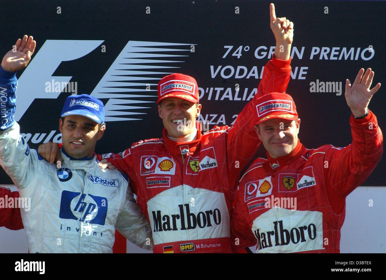 (dpa) - The winner of the Grand Prix of Italy, German formula one pilot Michael Schumacher of Ferrari (C), second-placed Colombian Juan Pablo Montoya of BMW-Williams (L) and third-placed Brazilian Rubens Barrichello of Ferrari (R), pose on the podium on the race track in Monza, Italy, 14 September 2 Stock Photo